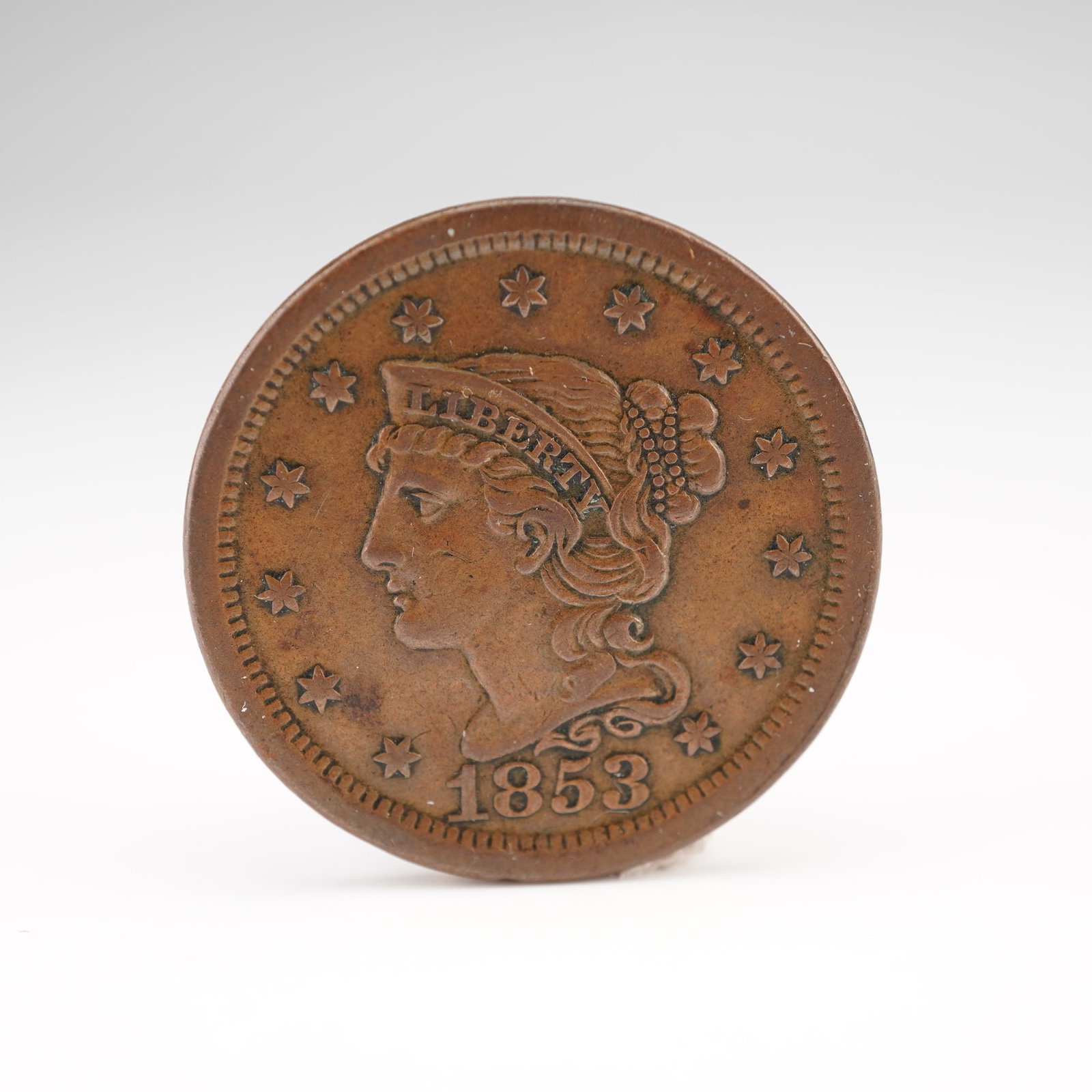 1853 Liberty Head Large One Cent: An 1853 United States Liberty Head Large Cent, struck in copper and featuring the classic Coronet Head design by Christian Gobrecht. The obverse depicts a left-facing bust of Lady Liberty wearing a co