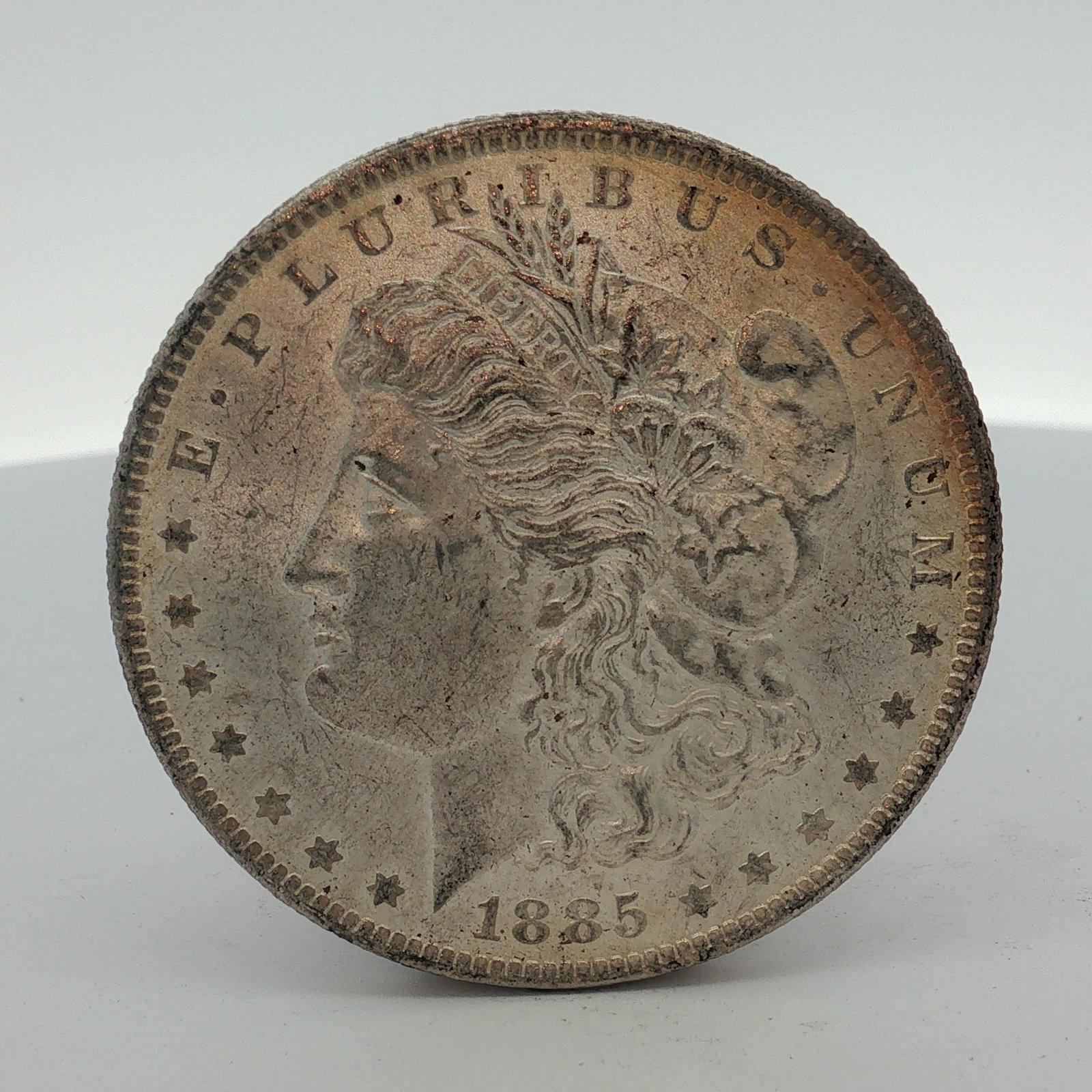 1885-O US Morgan Silver Dollar Coin Circulated: This US 1885-O Morgan dollar was struck at the New Orleans Mint. The coin is composed of 90% silver and 10% copper. The obverse features the Morgan dollar Liberty Head design, and the reverse features
