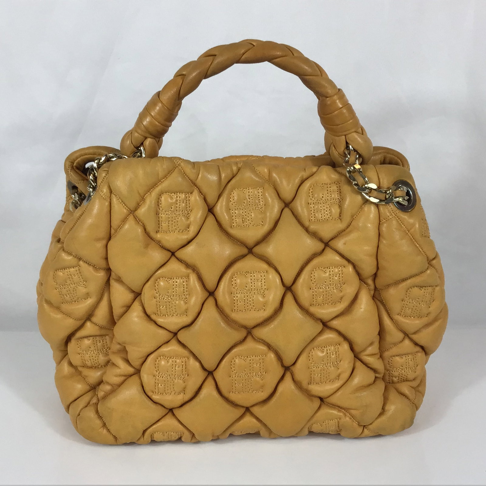 Carolina Herrera Quilted Yellow Leather Tote Bag: This CH Carolina Herrera tote is constructed from mustard yellow quilted nappa leather. The exterior features a signature padded quilt design incorporating an embossed CHHC monogram motif. It is equip
