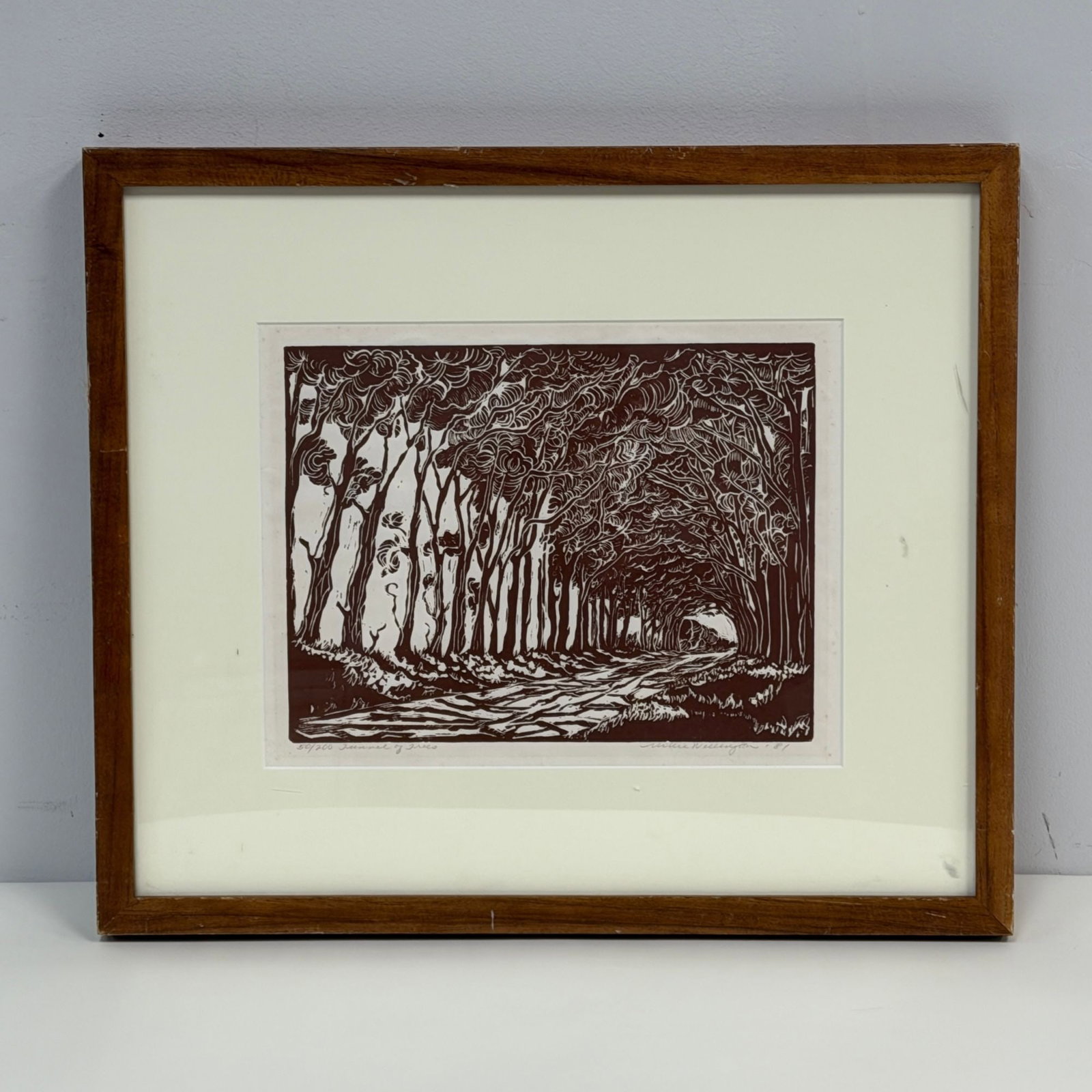 Millie Wellington (Australian 20th-21st century) Linocut on Paper, Tunnel of Trees, Signed: This monochrome linocut art relief print, titled Tunnel of Trees, is the work of Australian artist Millie Wellington. The piece is printed in a deep brown ink on paper and depicts a recessed forest ro