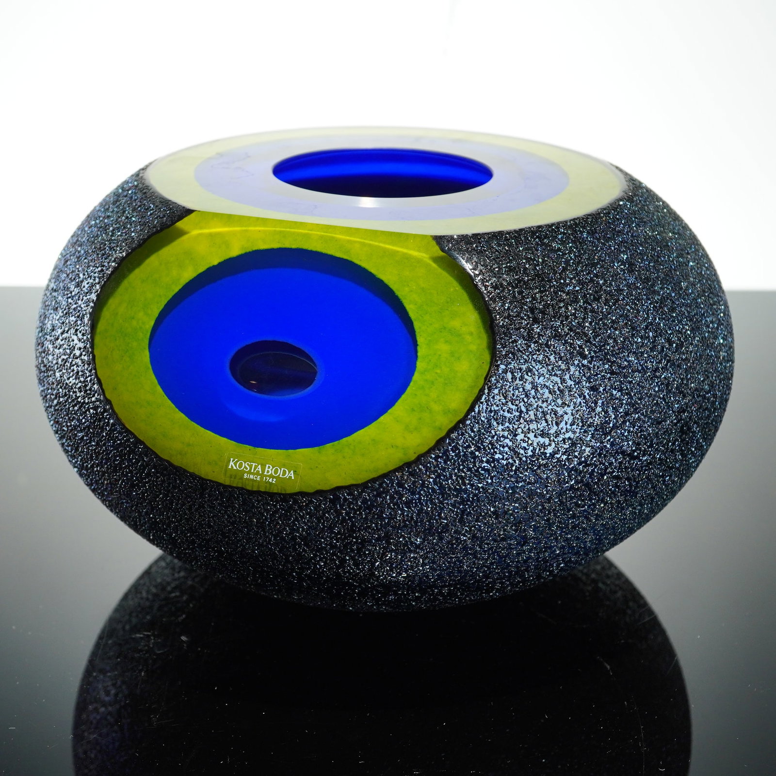 Monica Backstrom for Kosta Boda Art Glass Blue Vase, Moonlanding: A heavy, thick-walled art glass blue vase from the Moonlanding series designed by Monica Backstrom for Kosta Boda. The vessel features a squat ovoid form with a dense, textured iridescent midnight blu