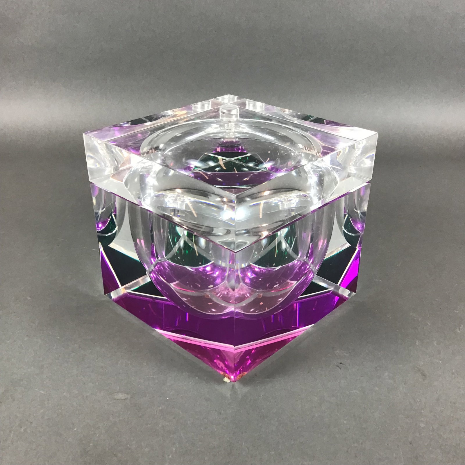 Mid-Century Lucite Acrylic Swivel Top Ice Bucket: The work is crafted from clear lucite acrylic and takes the form of a square clear ice box. The primary cubic body contains a deeply recessed hemispherical void, while a secondary smaller triangular p