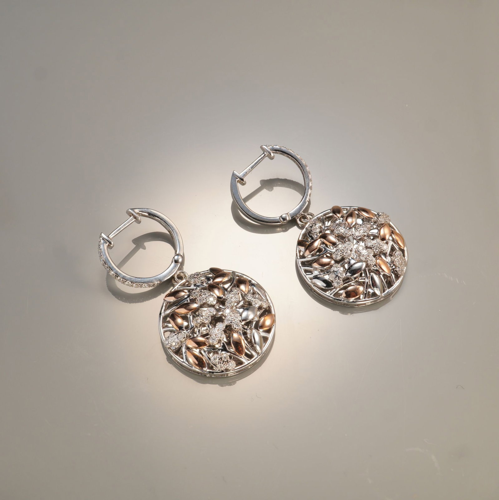 Pair of 14K Two-Tone Gold 0.52ctw Diamond Floral Dangle Earrings: A pair of 14K two-tone gold dangle earrings featuring a delicate mix of white and rose gold accented with a total of 92 round white diamonds totaling approximately 0.52 carat. Each earring showcases a