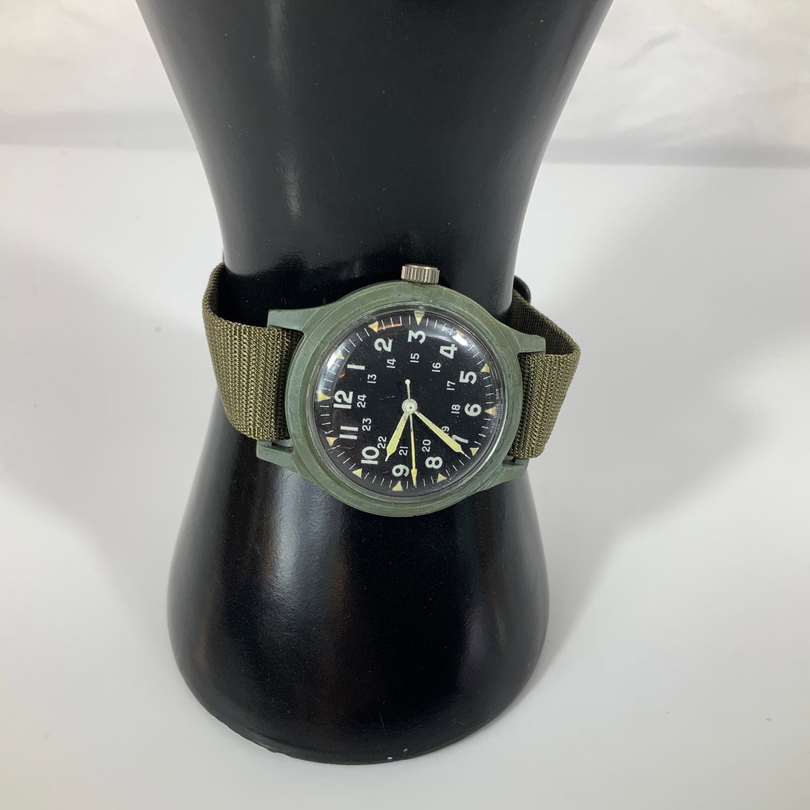 Benrus US Military Field Watch MIL-W-46374: A US military-issued field watch produced by Benrus under specification MIL-W-46374. The timepiece features an olive drab green composite case and a matte black dial. The dial displays white Arabic nu
