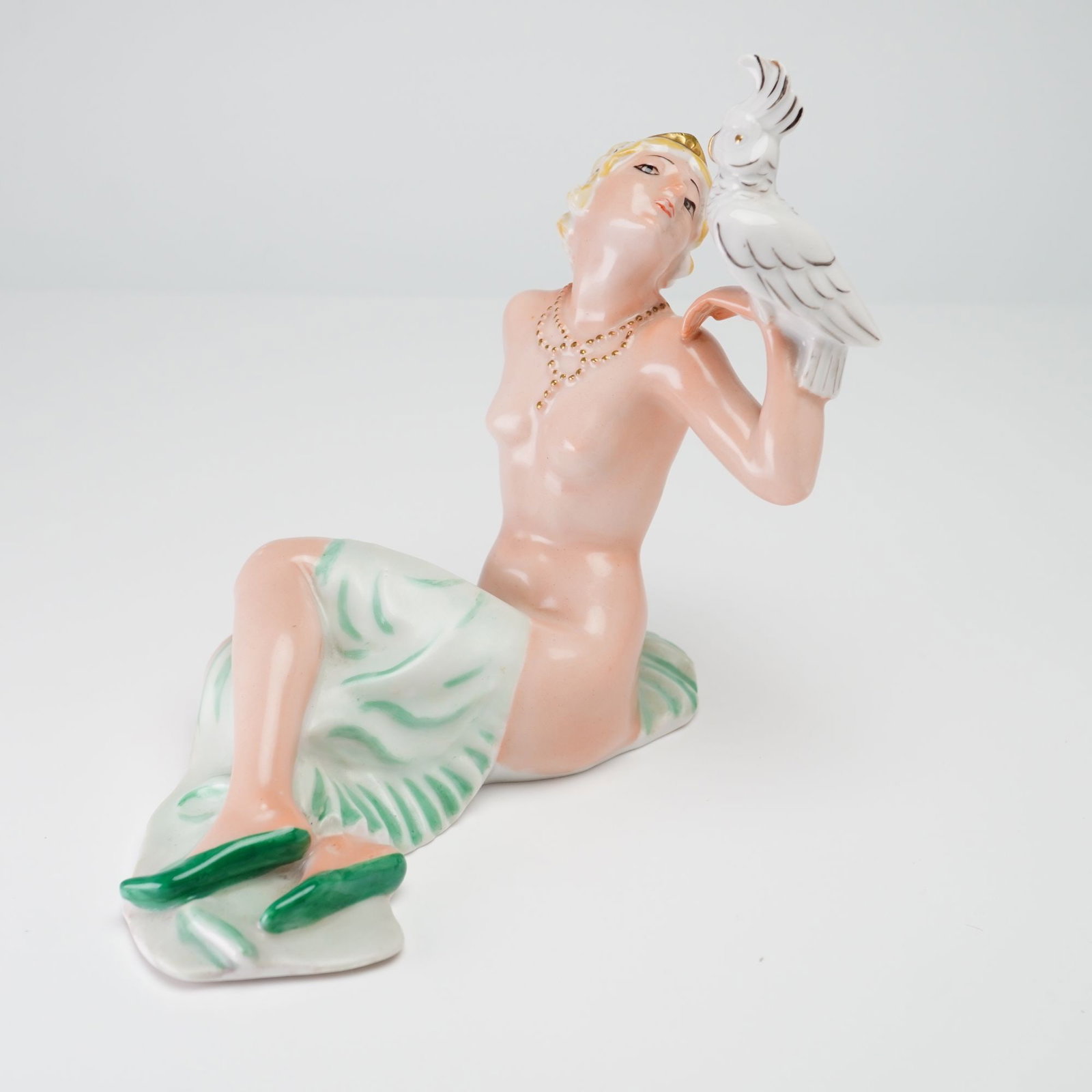 Hutschenreuther Art Deco Porcelain Figurine of Woman with Cockatoo by Karl Tutter: This Art Deco period figurine was manufactured by the Hutschenreuther porcelain factory in Selb, Bavaria, within the Abteilung fur Kunst or Art Department. The piece is attributed to the sculptor Karl