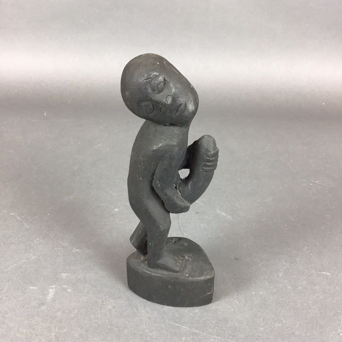 African Makonde Style Hand Carved Dark Wood Phallic Figure: A hand-carved wooden figure depicting a stylized male in a standing position, attributed to the Makonde carving traditions of East Africa. The object is fashioned from a dark-stained or naturally dark