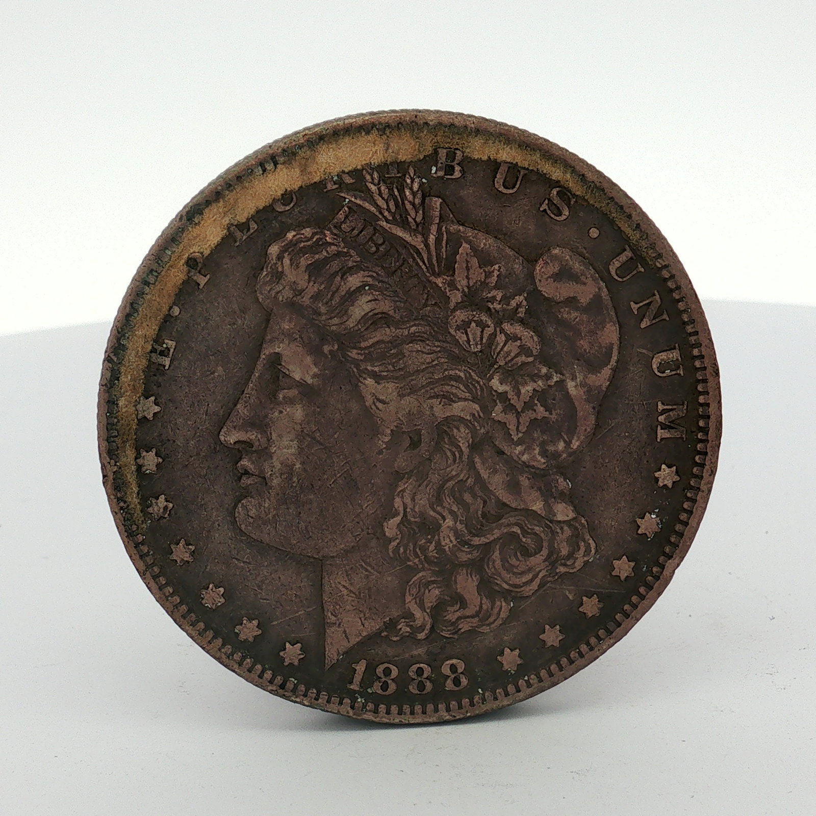 1888-O US Morgan Silver Dollar Coin Circulated: This struck coin features the Liberty Head obverse and the Eagle with Wreath reverse. The New Orleans mint mark is visible on the reverse above the denomination. The piece exhibits a dark reddish-brow