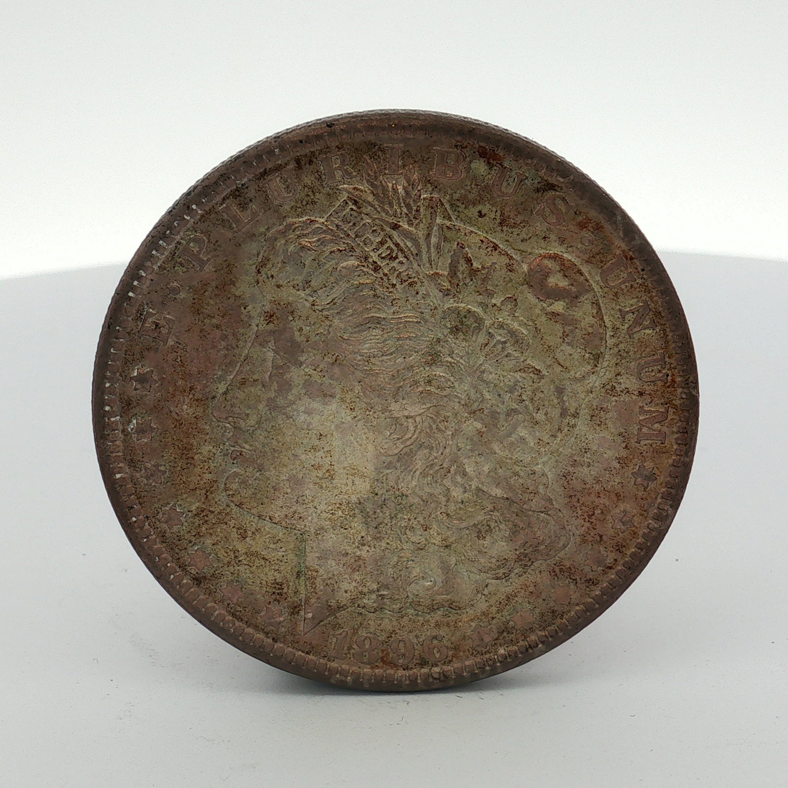 1896-O US Morgan Silver Dollar Coin Circulated: This US 1896-O Morgan silver dollar was struck at the New Orleans Mint. The coin features the Morgan dollar obverse and reverse designs. The O mint mark is visible on the reverse above the DO in DOLLA