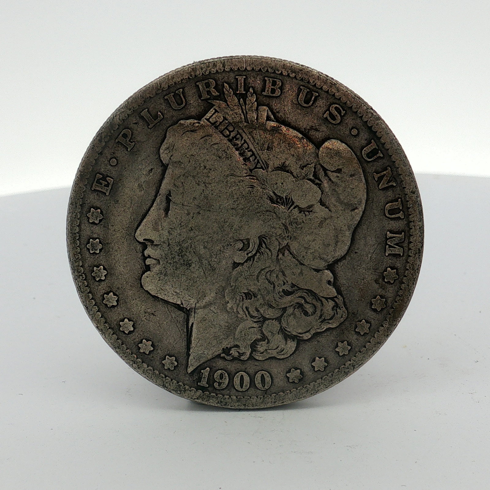 1900-O US Morgan Silver Dollar Coin Circulated: This US 1900-O Morgan dollar coin was struck at the New Orleans Mint. The coin is composed of 90% silver and 10% copper (.900 fine silver). It features the Liberty head obverse and the heraldic eagle 
