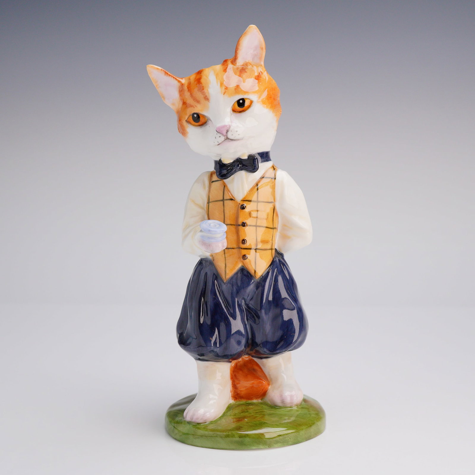 Royale Stratford Hand Painted Bone China Cat with Yo-Yo Figurine: A hand-painted, glazed bone China figurine by Royale Stratford in Staffordshire, England. This limited edition piece depicts an anthropomorphic orange and white tabby cat standing upright and dressed 