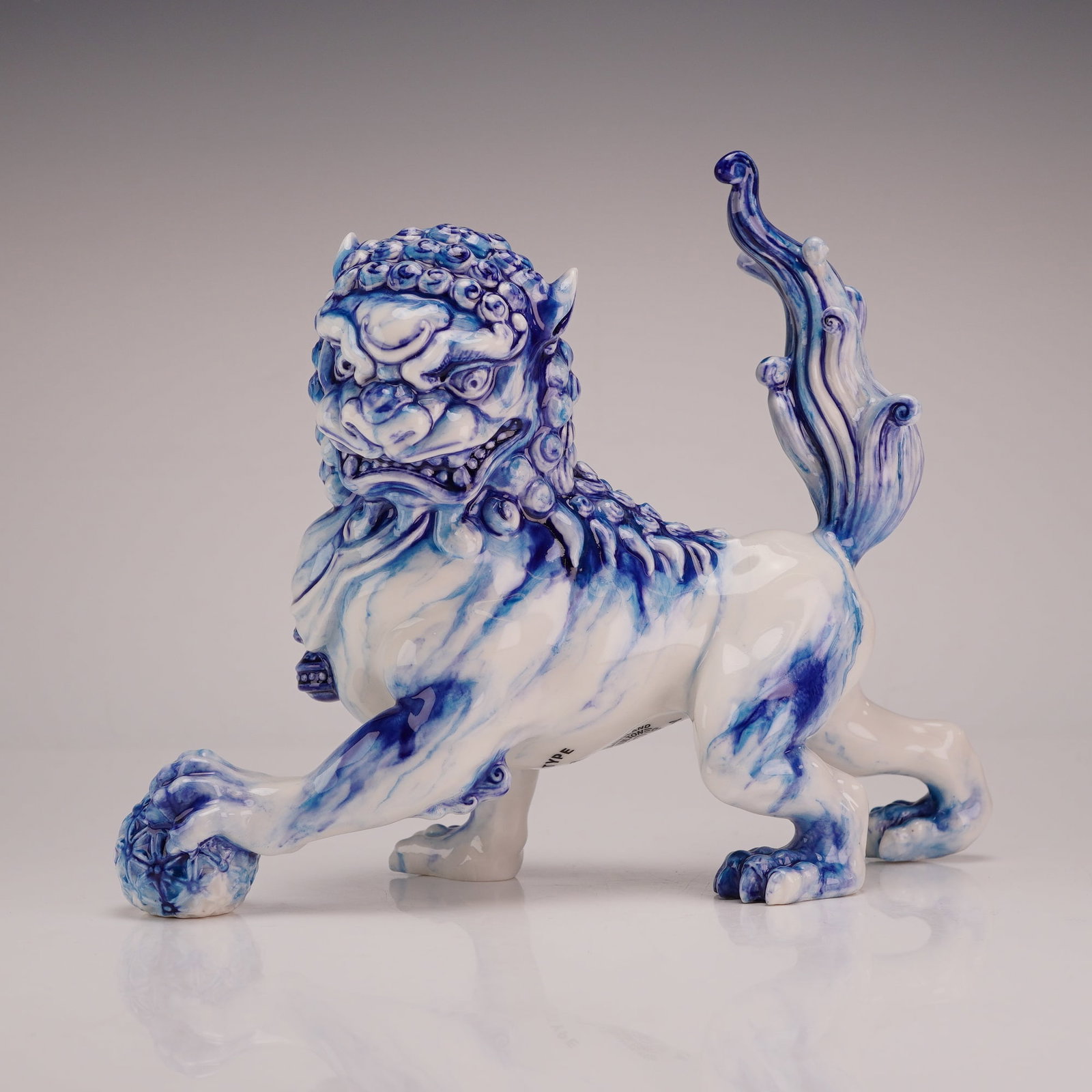 Royal Doulton Blue and White Flambe Prototype Foo Dog Figurine: Royal Doulton porcelain figurine titled Dog of Fo, modeled as a traditional Chinese guardian lion. The figure is depicted in a crouching posture with the right forepaw resting upon a reticulated broca