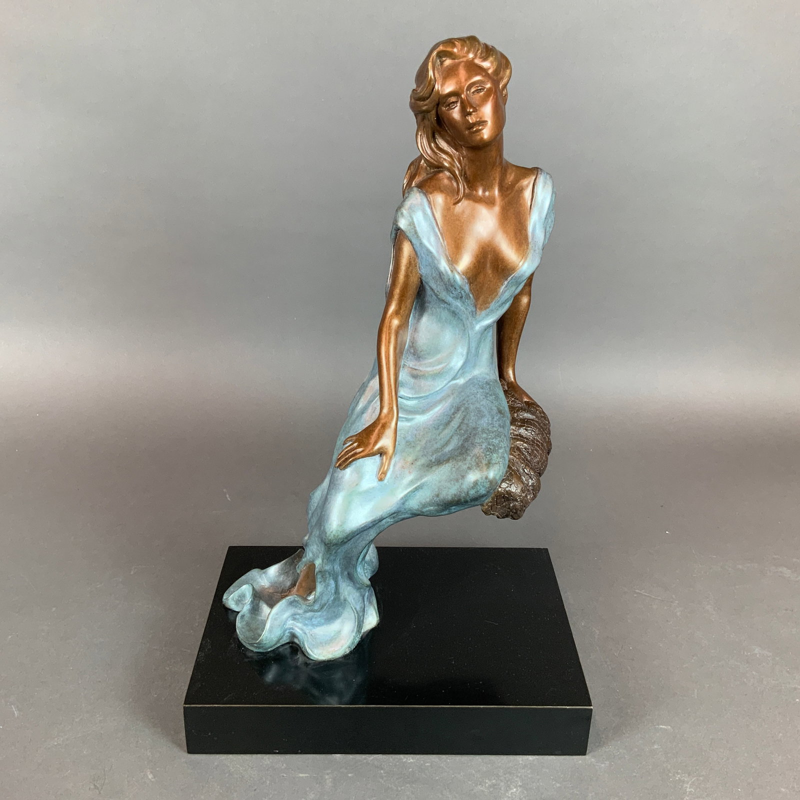 Alice Riordan (American, 20th-21st century) Art Deco Bronze Sculpture, Signed & Numbered: This cast bronze sculpture titled Memories is by American artist Alice Riordan. The work depicts a stylized female figure in a leaning pose, wearing a long, flowing gown. The sculpture features a dual
