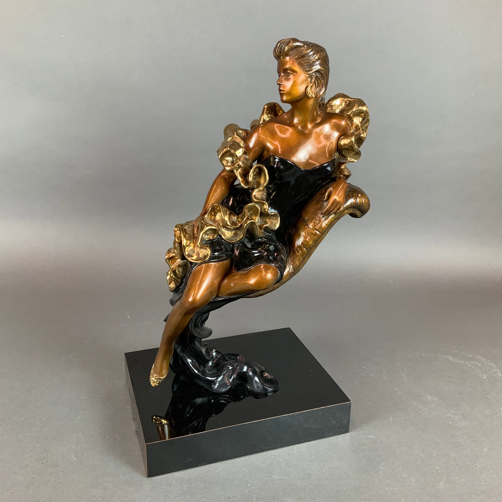 Alice Riordan (American, 20th-21st century) Art Deco Bronze Sculpture, Signed & Numbered: This bronze sculpture titled Evening is the work of artist Alice Riordan. Executed in polychrome cold-cast bronze, the piece depicts a stylized female figure in a dynamic, sweeping pose characteristic