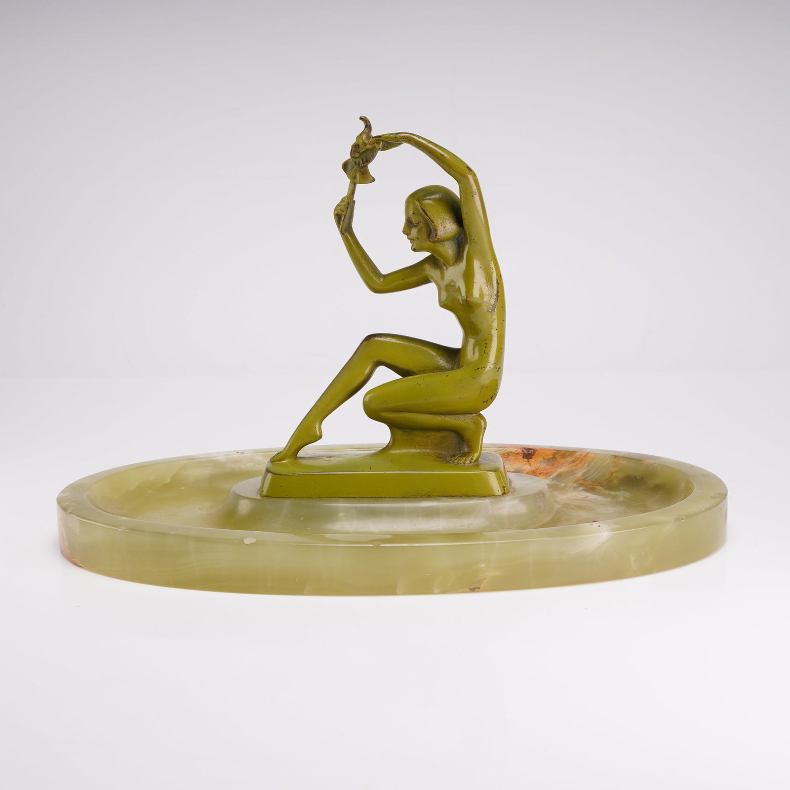 J. Ulrich (Austrian, 1857-1930) Art Deco Cold-Painted Metal and Onyx Vide-Poche for B. Altman and: This Art Deco vide poche or tray features a central cold-painted metal figurine mounted on an oval stone base. The figurine, identified as the work of J. Ulrich, depicts a stylized nude woman in a cro