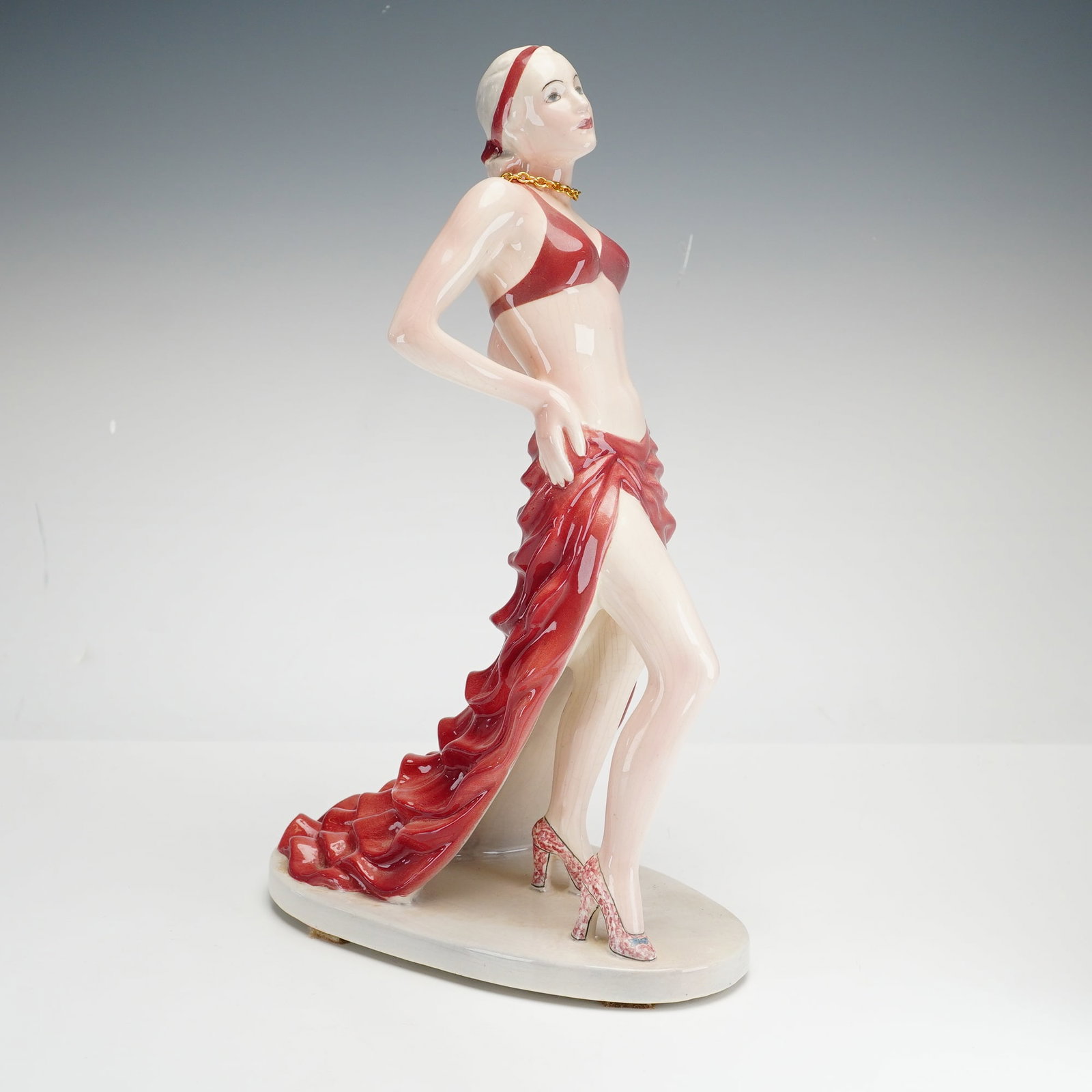 American Goldscheider Ceramic Art Deco Sculpture by Helen Liedloff: This Art Deco style ceramic sculpture was produced by the American Goldscheider Corp. in the United States. The figure is depicted in a dramatic pose, looking upward and to her left with one hand rest