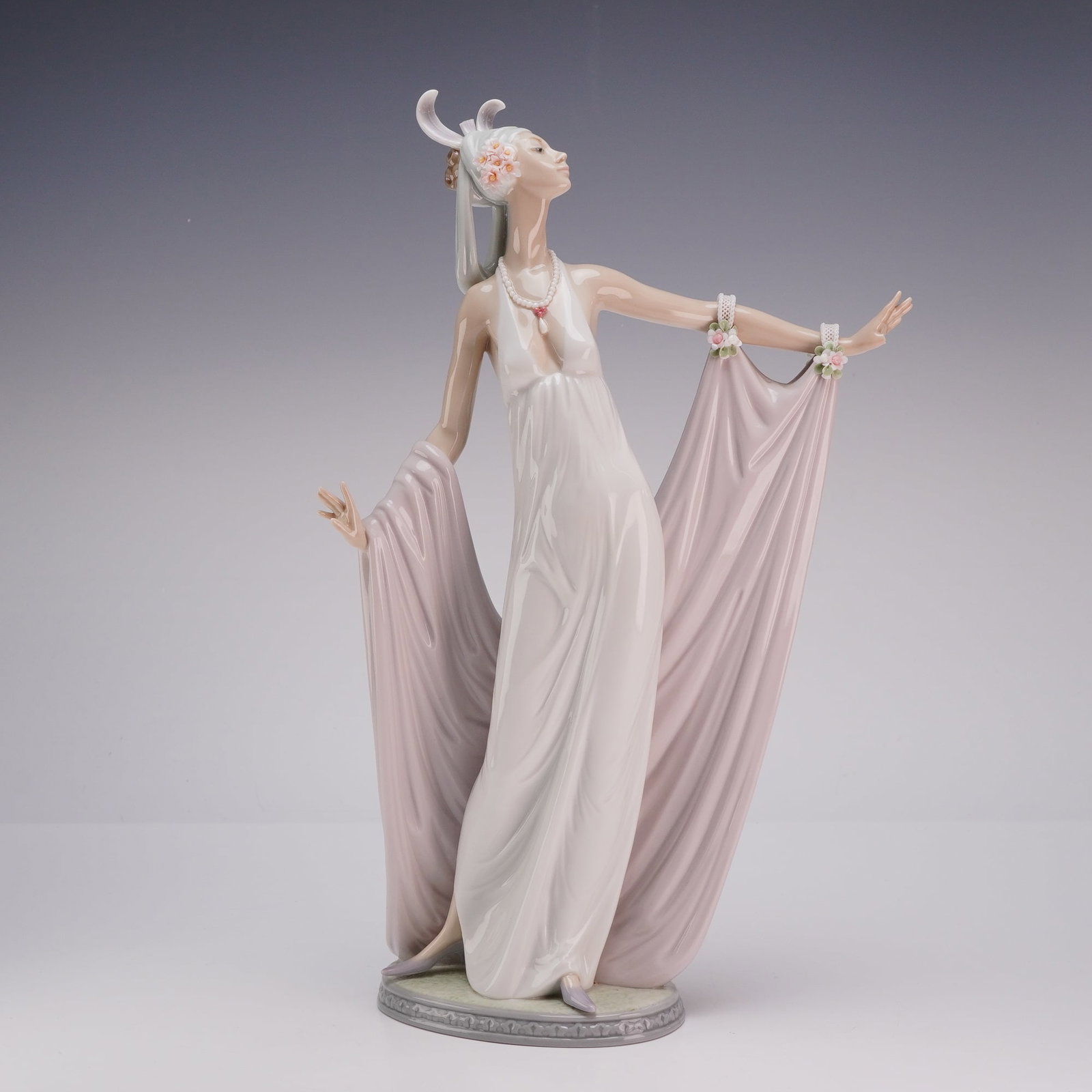 Lladro Porcelain Sculpture Grand Dame 01001568: This Lladro glazed porcelain figurine, titled Grand Dame and identified as model number 1568, depicts a female figure in 1920s style evening attire. The subject is dressed in a floor-length white gown