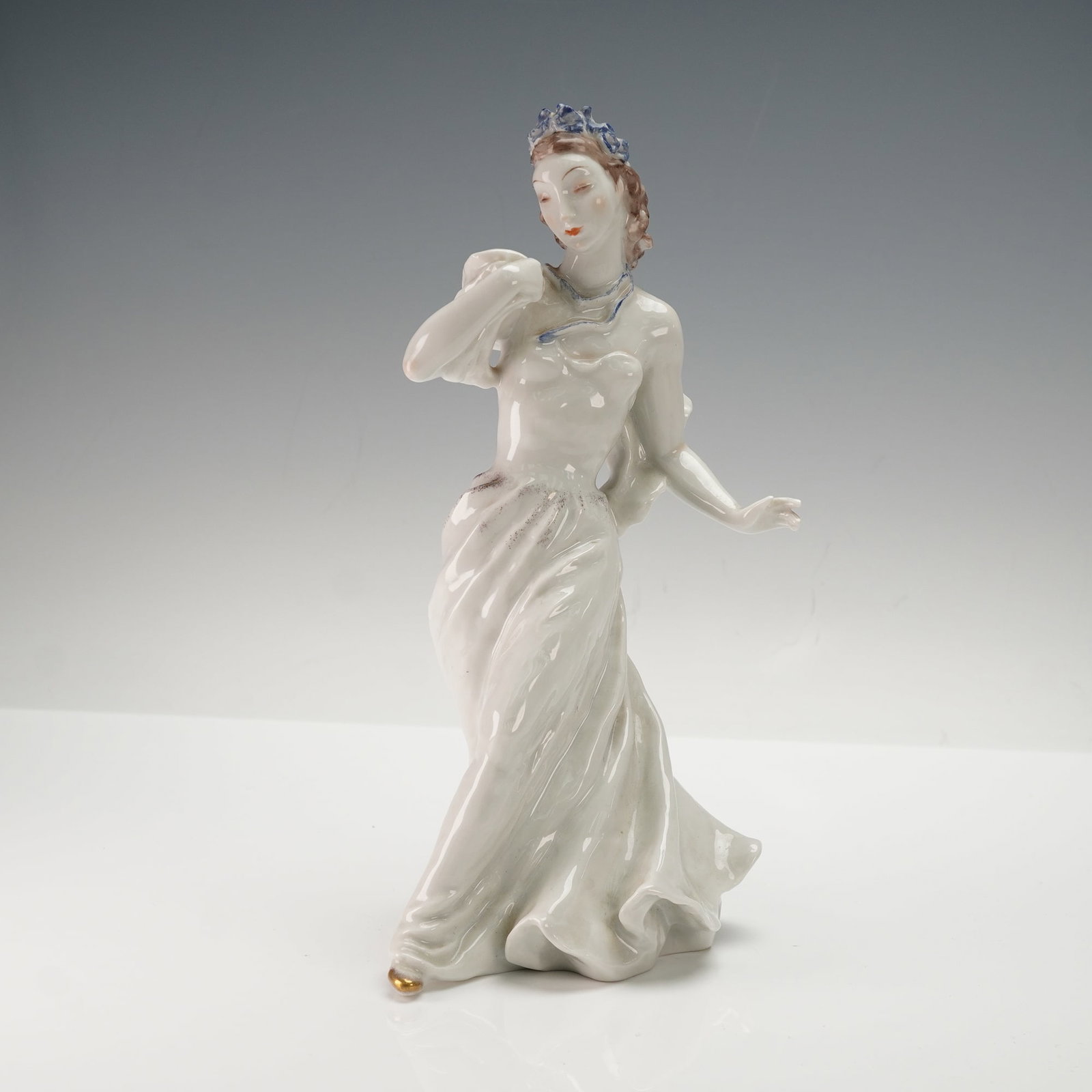 Rosenthal Porcelain Figurine, Melody, Designed by Friedrich Gronau: A rare Rosenthal porcelain figurine, model number 1897, designed by Friedrich Gronau. The figurine depicts an elegant female figure in a flowing white gown, adorned with a blue crown, matching necklac