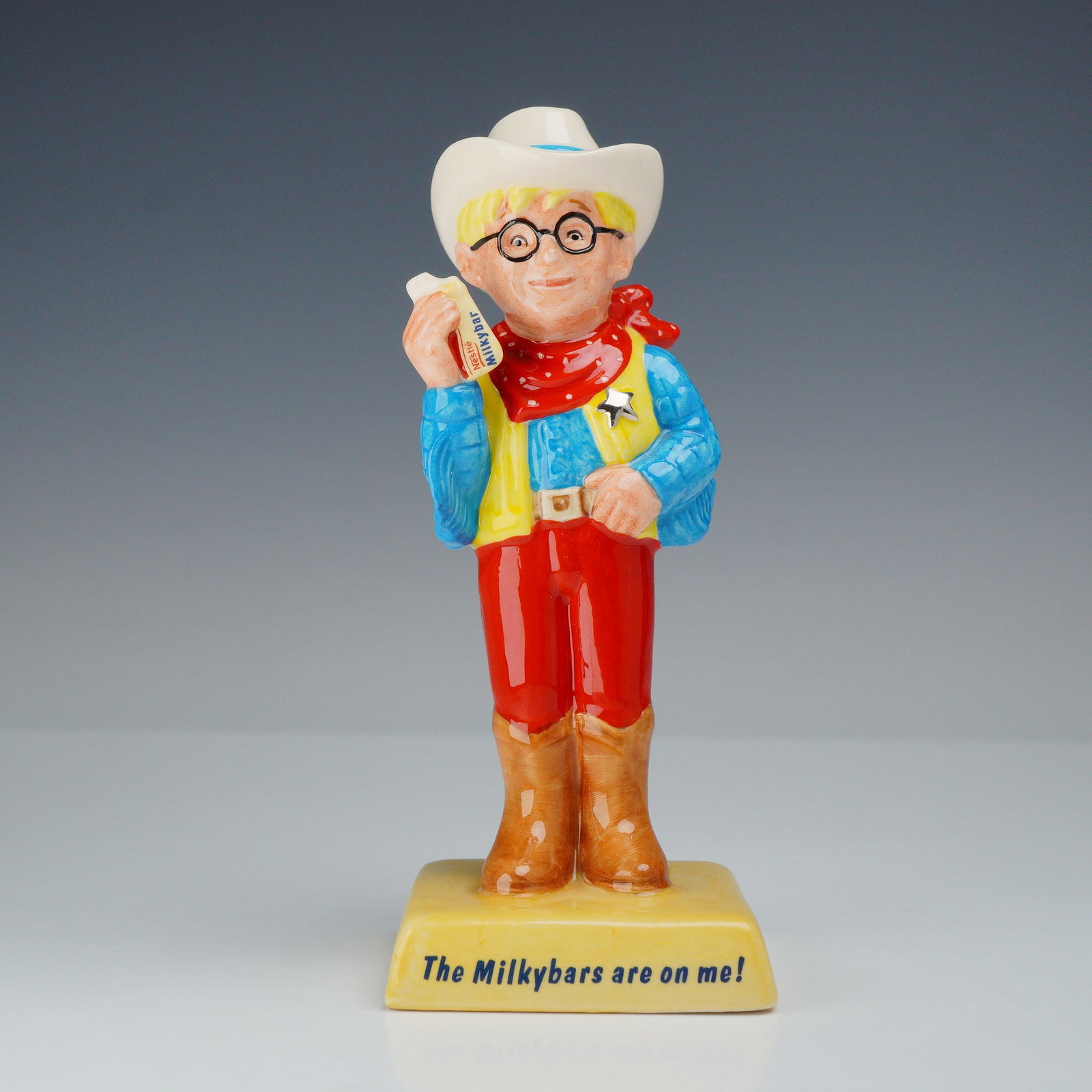 Royal Doulton Advertising Classics Limited Edition Figurine, The Milkybar Kid AC7: This Royal Doulton glazed porcelain figurine depicts the iconic advertising mascot The Milkybar Kid, designated as model AC 7 within the Advertising Classics series. The character is portrayed as a yo