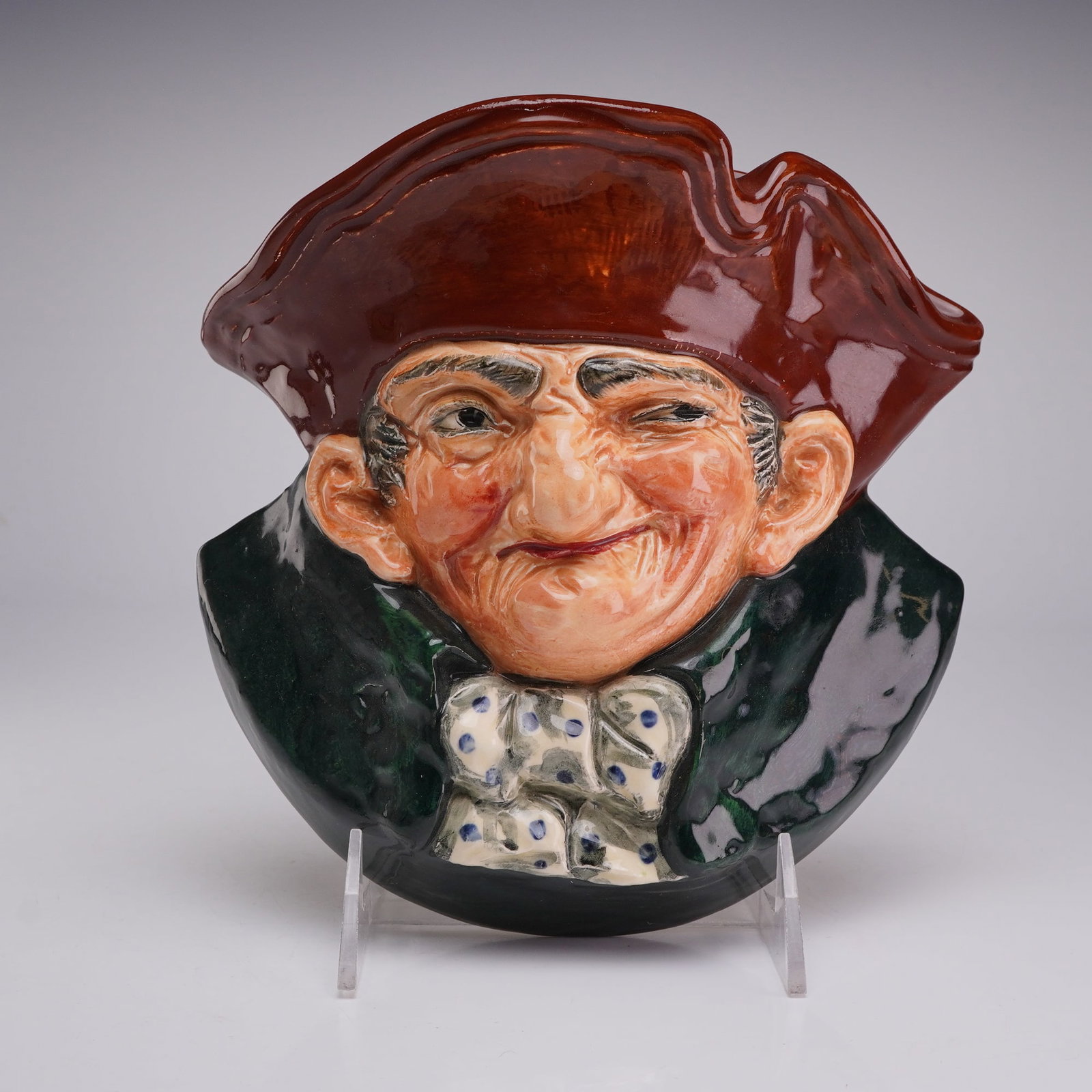 Royal Doultonx Ceramic Wall Pocket, Old Charley D6110: This Royal Doulton glazed ceramic wall pocket depicts the character Old Charley, identified by model number D6110. The piece is modeled in high relief as a character head featuring a man with a winkin