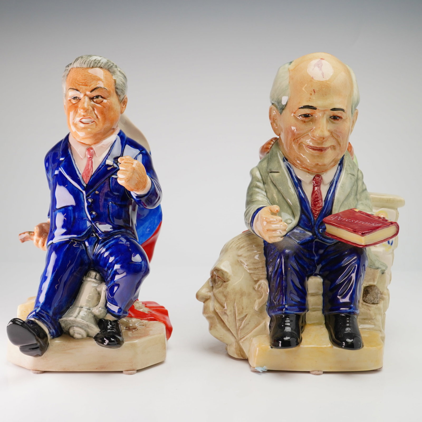 Two Kevin Francis Ceramics Limited Edition Toby Jugs, Boris Yeltsin and Mikhail Gorbachev: This pair of satirical glazed ceramic character jugs was produced by Kevin Francis Ceramics in Staffordshire, England. The first figure depicts Boris Yeltsin in a blue suit, seated upon a military tan
