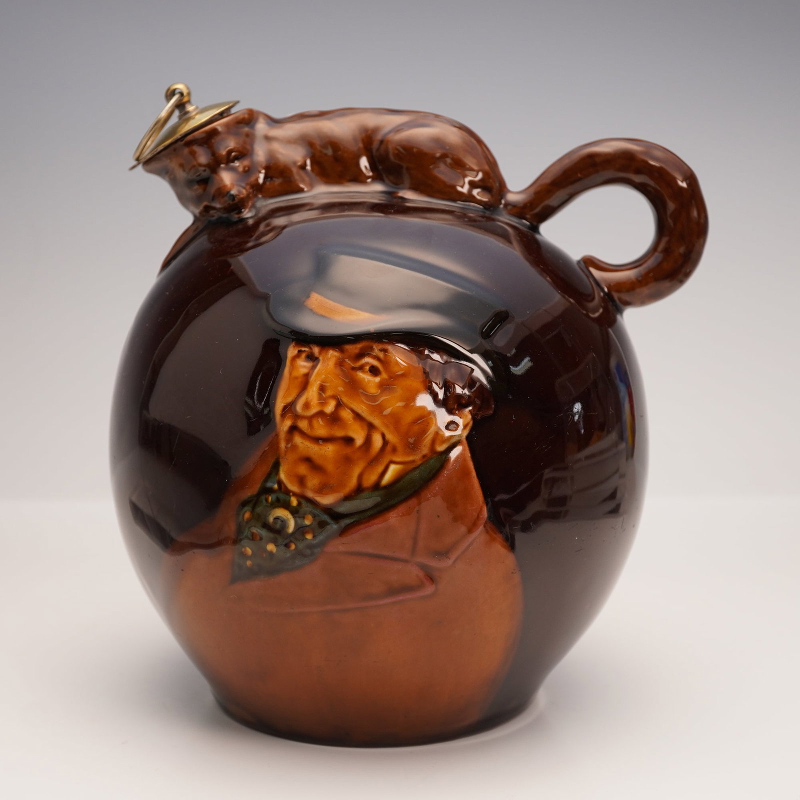 Royal Doulton Kingsware Master of the Foxhounds Flagon with Fox: This Royal Doulton Kingsware Master of the Foxhounds Flagon features a crouching fox on top with its tail forming the handle and its body shaping the spout. The face of the flask depicts the Sporting 