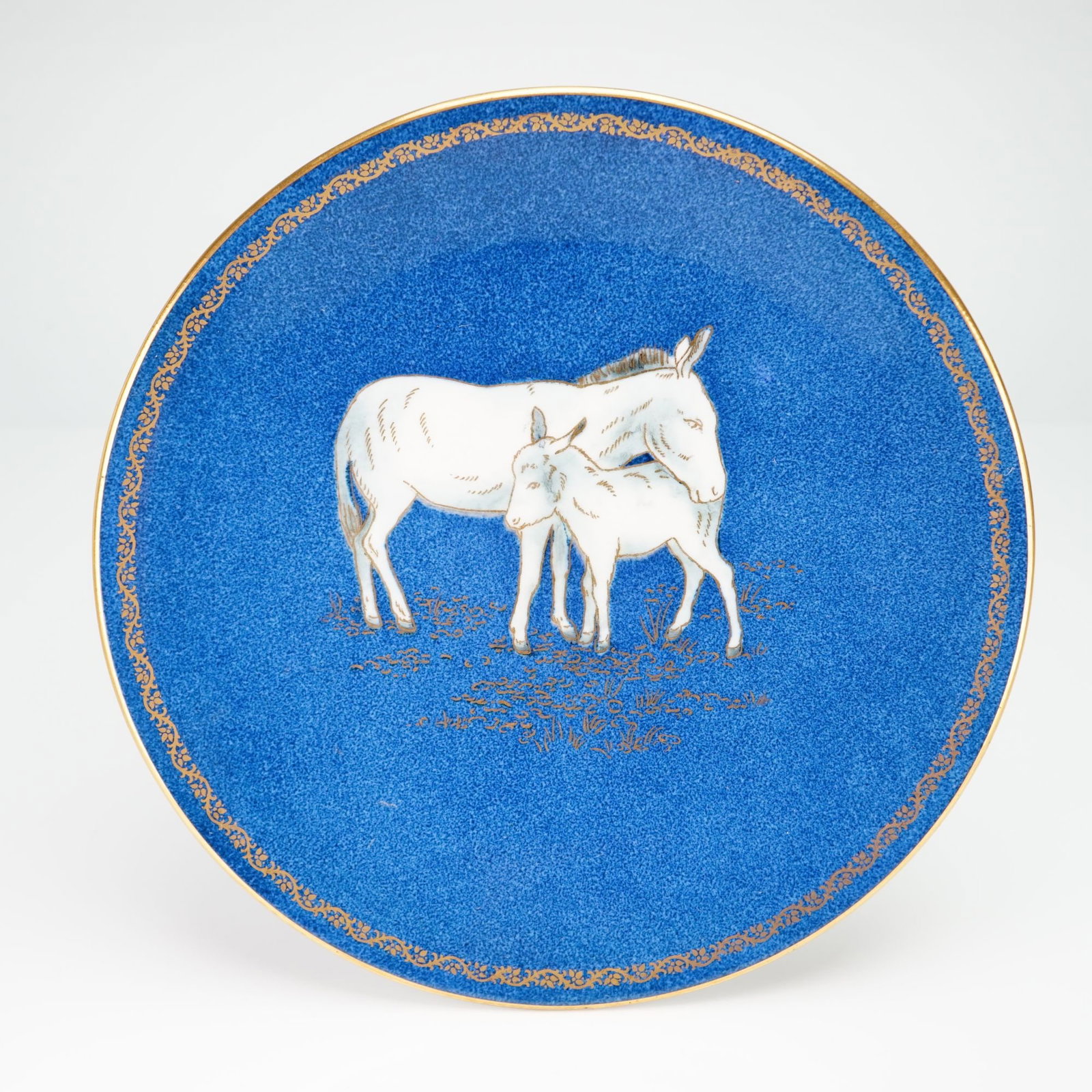 Wedgwood Blue Lustre Bone China Plate with Donkey and Foal from the Rubin Collection: This Wedgwood bone china cabinet plate features a mottled powder blue ground with a central motif of a white donkey and foal. The animal figures are transfer-printed and hand-finished, set against gil