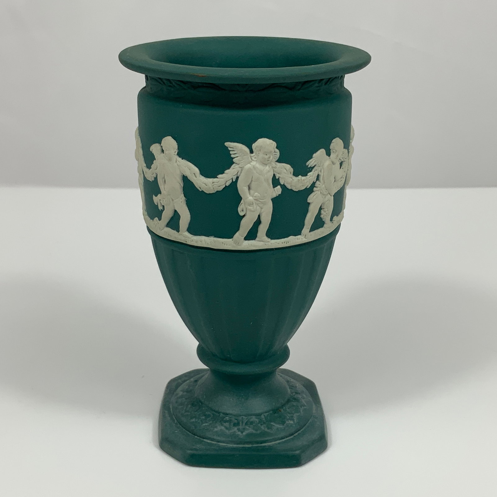 Wedgwood Sage Green Jasperware Miniature Pedestal Flower Vase: This miniature pedestal flower vase is manufactured by Wedgwood in England. It is crafted from sage green Jasperware, a matte, unglazed stoneware. The vessel features an urn-shaped body with a wide, f