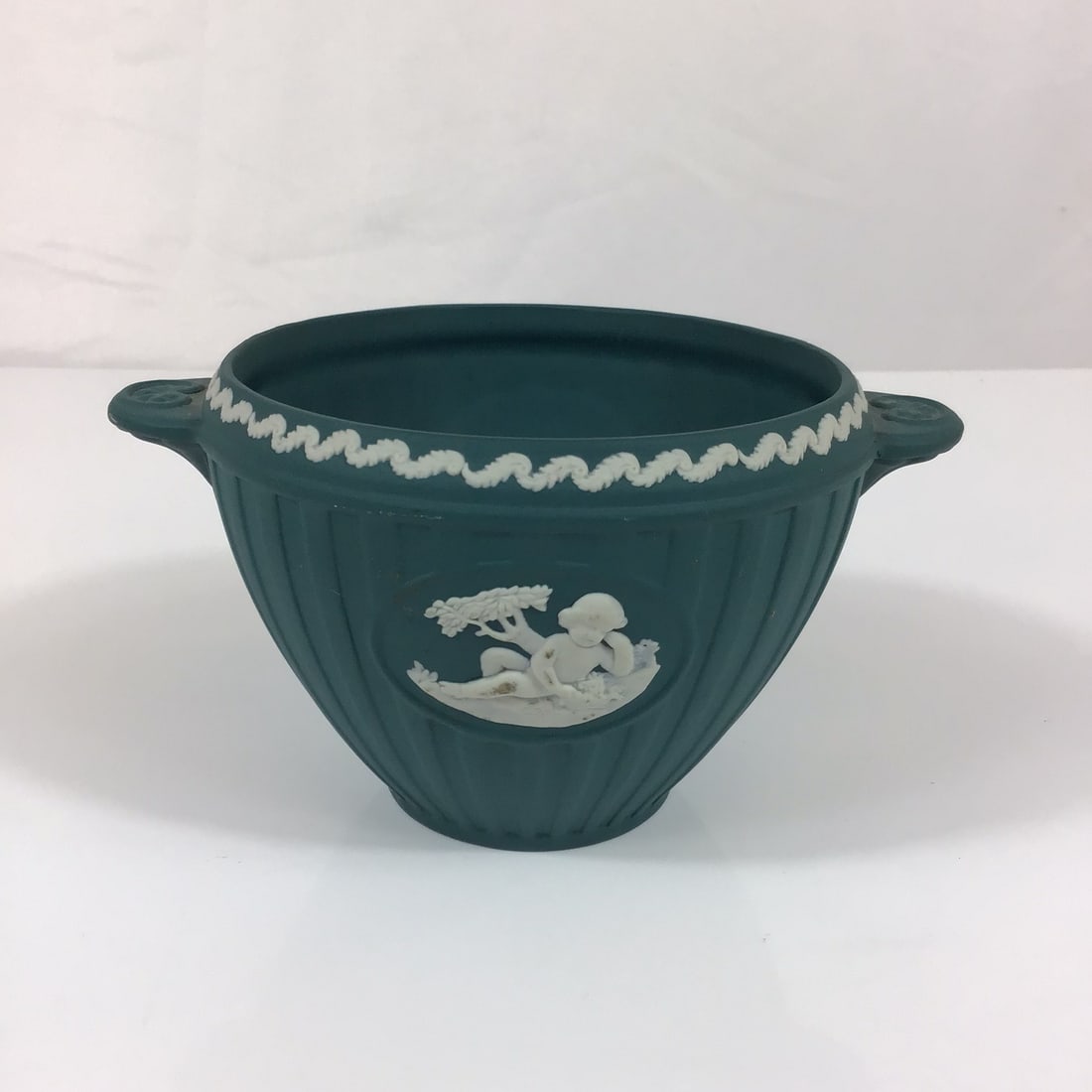 Wedgwood Spruce Green Jasperware Bacchus Bowl: A Wedgwood Jasperware Bacchus bowl, also categorized as a small vase, featuring a spruce green matte-finish stoneware body. The vessel is designed with a footed, circular form and vertical fluting alo