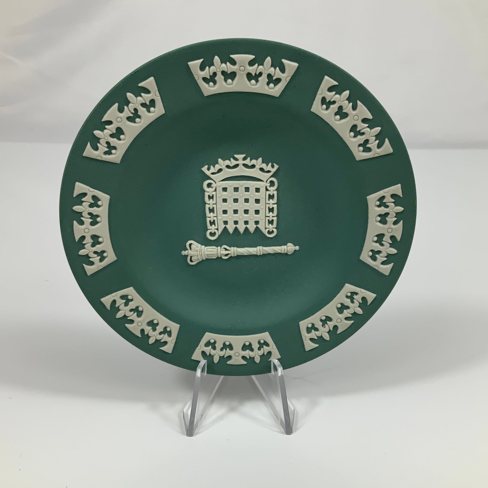 Wedgwood Jasperware Sage Green and White Saucer Dish: A Wedgwood Jasperware sage green and white saucer dish. This circular item is crafted from matte-finish stoneware featuring applied white bas-relief sprigged decoration. The central motif depicts the 