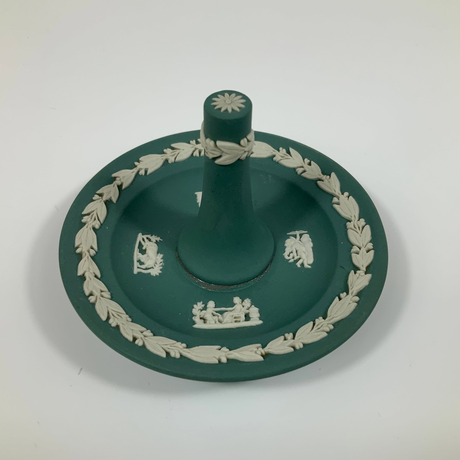 Wedgwood Sage Green Jasperware Commemorative Ring Holder: This Wedgwood sage green Jasperware ring holder is a commemorative piece manufactured in England. The item is constructed from matte green stoneware featuring white sprigged relief decoration. The cir