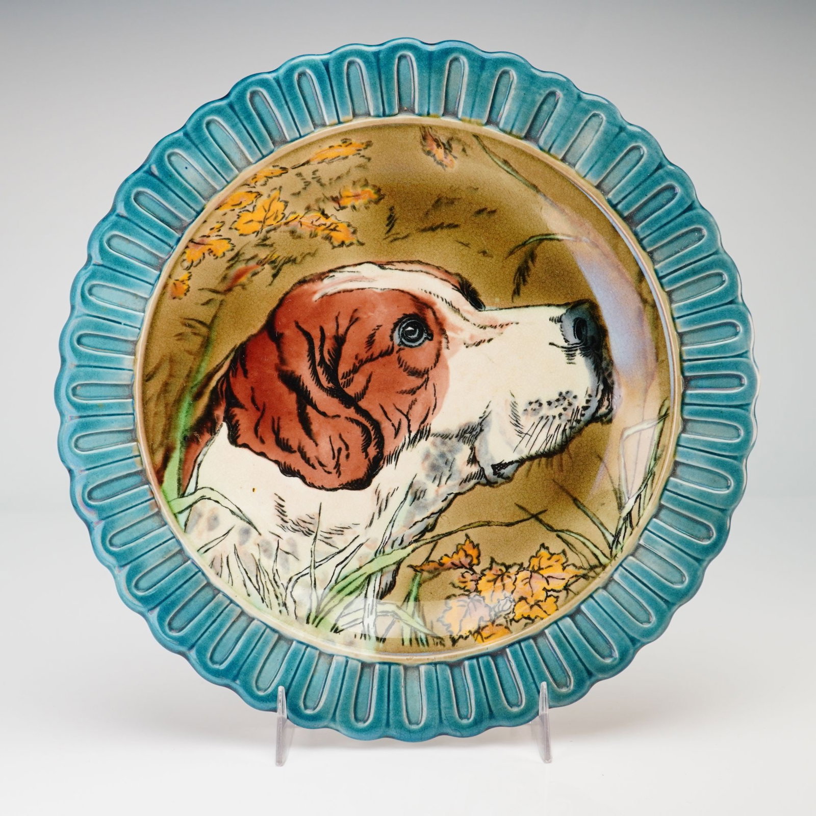 Wedgwood Majolica Hunting Dog Plate from the Rubin Collection: This glazed earthenware plate from the Rubin Collection features a hand-painted central portrait of a hunting dog, likely a setter or pointer, depicted in profile against a background of grasses and a