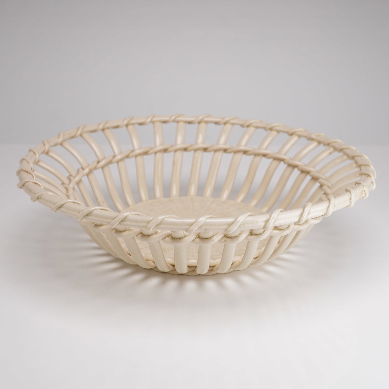 Wedgwood Creamware Open Weave Basket, 19th Century, Reticulated Lattice Design: A fine Wedgwood creamware basket featuring an intricate openwork lattice-wall design. This glazed ceramic piece is executed in a classic cream color, characteristic of 18th and 19th-century English po