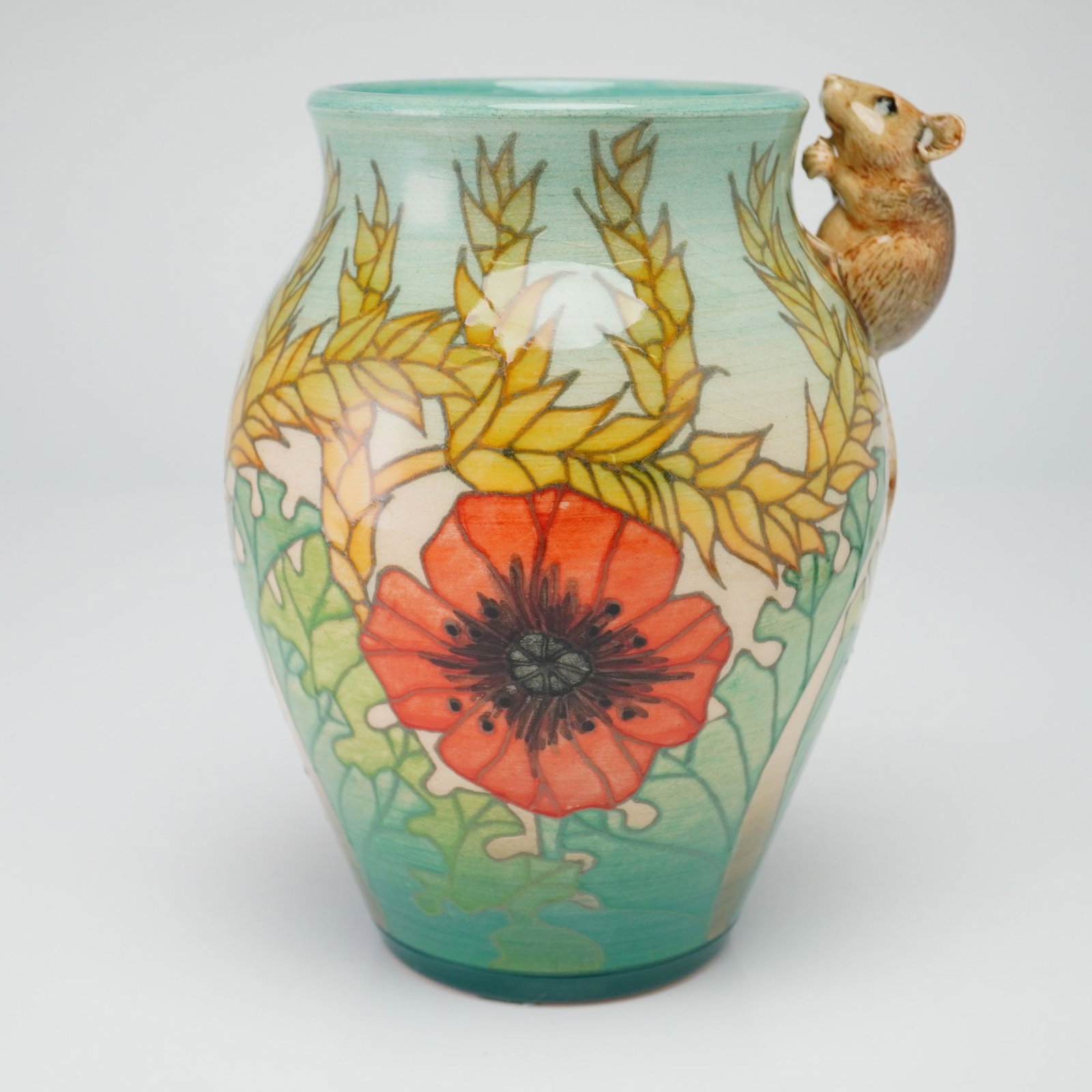 Dennis China Works Pottery by Sally Tuffin Vase, Corn and Poppy with Mouse: The earthenware vessel is crafted using the tube-lining technique and features hand-painted red poppies and golden wheat stalks against a graduated background transitioning from pale turquoise to fore