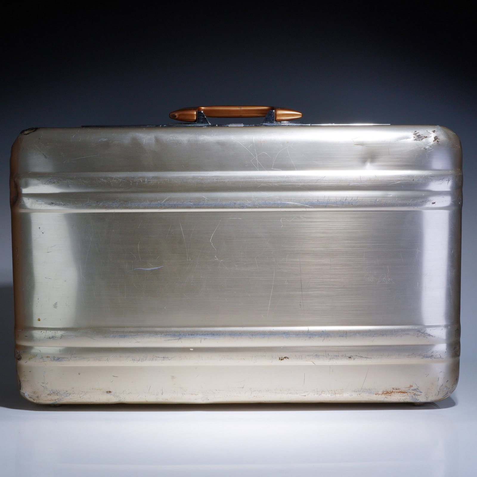 Vintage Zero Halliburton Gold Aluminum Briefcase: The aluminum briefcase featuring a gold color brushed metal exterior is constructed with the manufacturer signature horizontal ribbing. The front is equipped with a chrome-plated latch assembly emboss