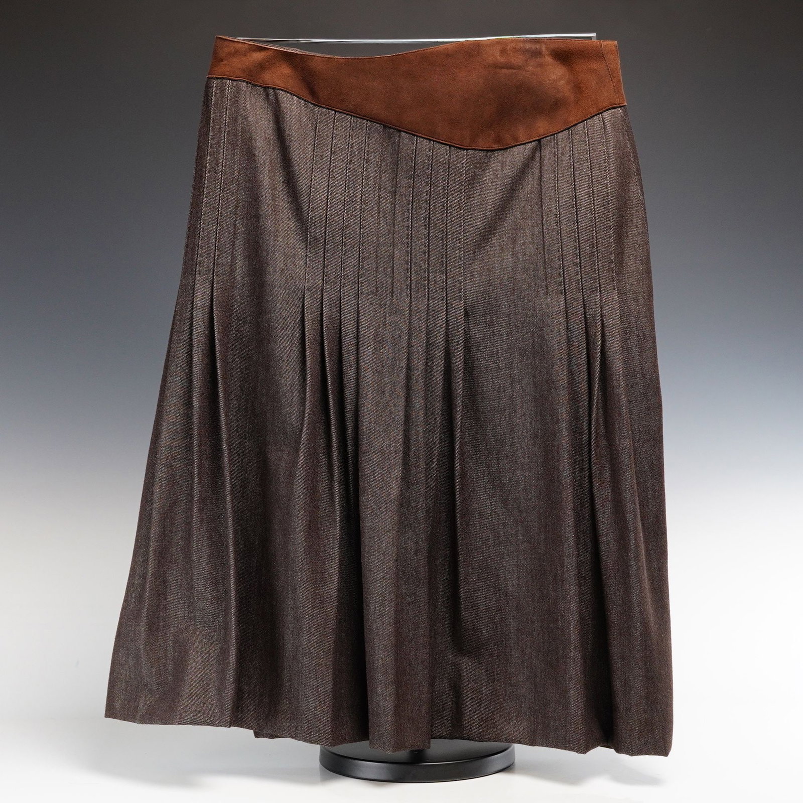 Akris Bergdorf Goodman Wool and Cotton Midi Skirt: This Akris midi skirt, produced for Bergdorf Goodman, is crafted from a dark chocolate brown wool and cotton twill. The garment features a signature asymmetric, contoured waistband in brown suede leat