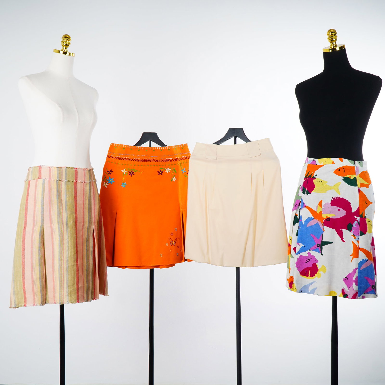 Four Moschino Cheap and Chic and Akris punto Pleated Skirts: This collection consists of four midi-length pleated skirts dating from the late 20th century, including three pieces by Moschino Cheap and Chic and one by Akris punto. The three Moschino skirts are c