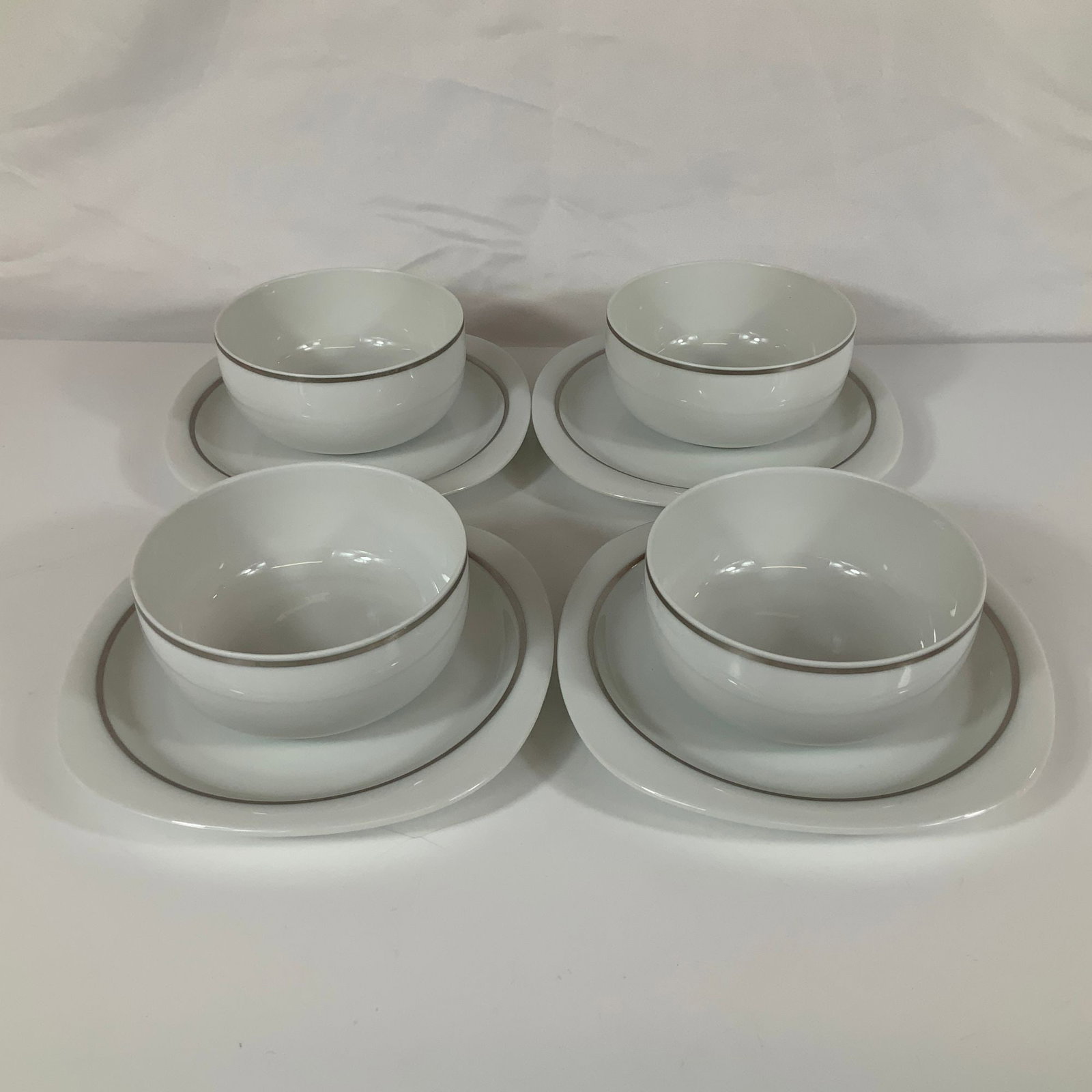 8pc Rosenthal Studio-Linie Porcelain Fruit Bowls and Dessert Plates: This eight-piece set of Rosenthal Studio-Linie porcelain consists of four fruit bowls and four dessert plates. The items are crafted from white porcelain and feature a minimalist design with a thin,