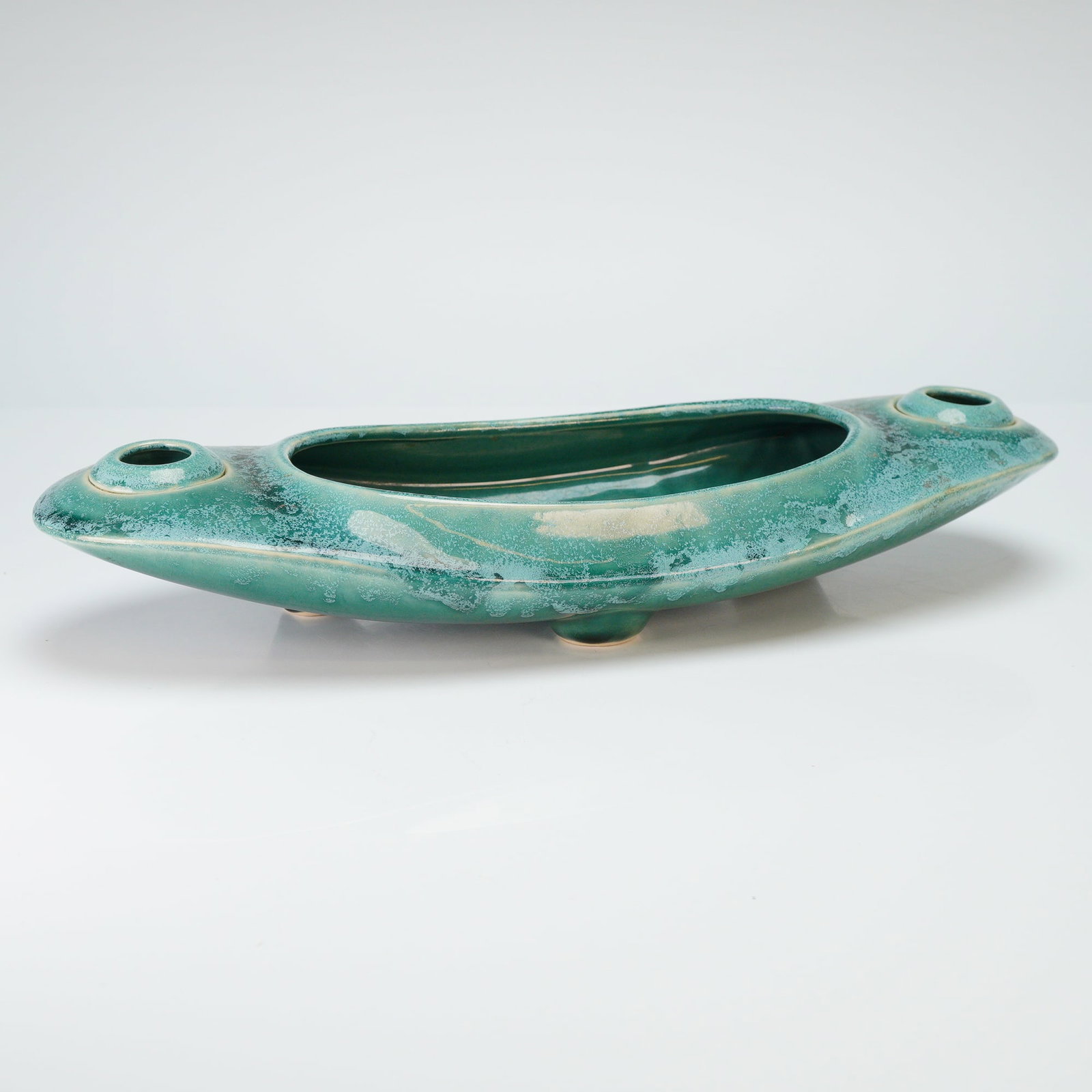 Bush McCoy Candleholder Planter: A Mid-Century Modern ceramic console bowl and integrated candle holder produced by Brush Pottery, USA. This boat-shaped or navette-form vessel features a low profile resting on three small integral fe