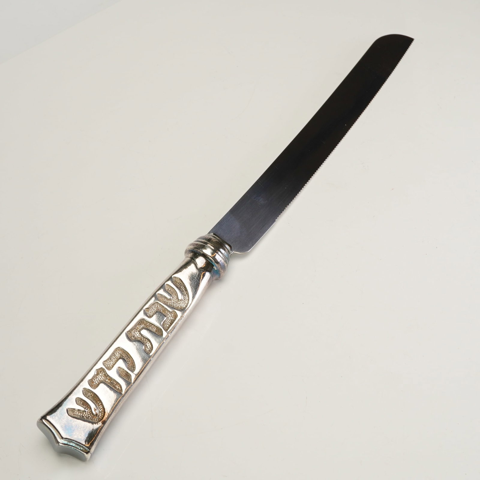 Hazerfim Sterling Silver Handle Challah Knife Holy Sabbath: This Challah knife features a 925 sterling silver handle and a stainless blade. The handle is designed with a flared base and a decorative bolster, featuring a recessed rectangular panel, Hazerfim