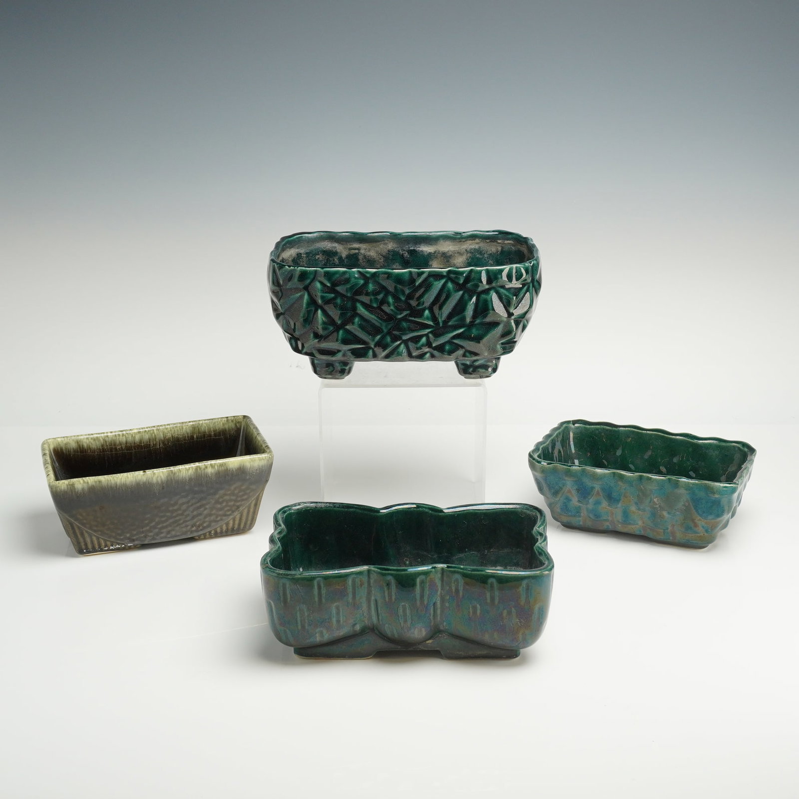 4pc Hull and Upco Green Pottery Bowls: A collection of four mid-century modern ceramic planters and bowls by Hull and UPCO (Ungemach Pottery Company). The group features various geometric and organic forms finished in dark green and olive 