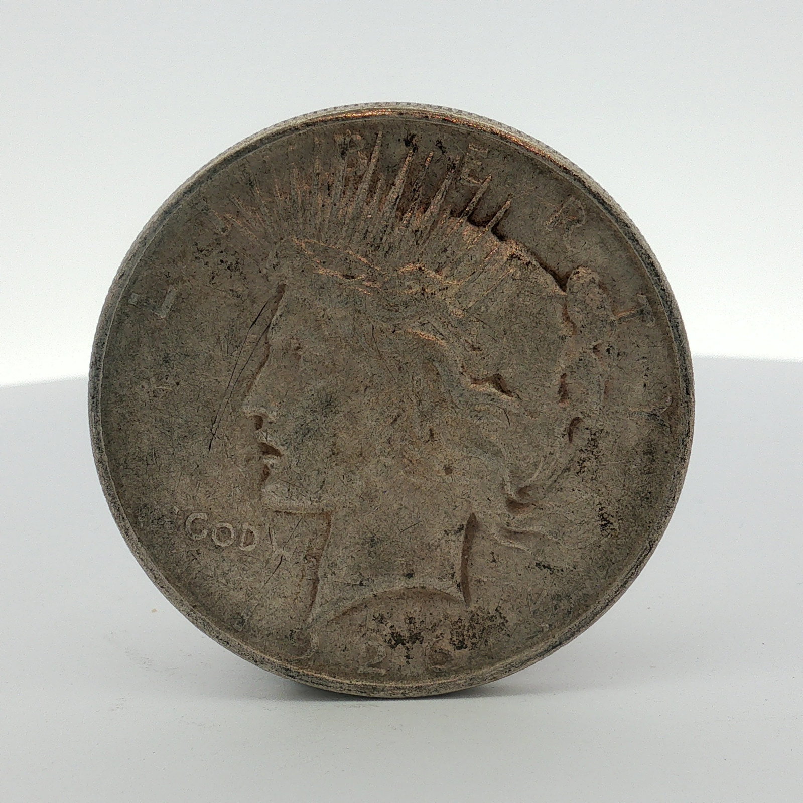 1926-D US One Dollar Peace Silver Dollar, Circulated: This US 1926-D Peace silver dollar is struck in 90% silver and 10% copper at the Denver Mint. The coin features the standard Peace dollar design with a reeded edge. The obverse bears the date 1923 and