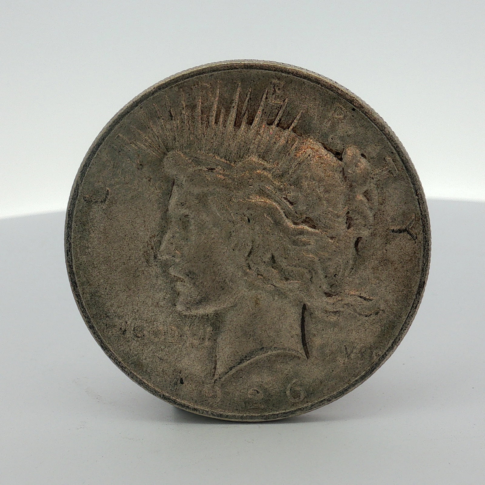 1926-D US One Dollar Peace Silver Dollar, Circulated: 1926 US Peace silver dollar. Struck at the Denver Mint. Metal composition is 90% silver and 10% copper with a fineness of .900. The obverse features the Liberty head design. The reverse features the E