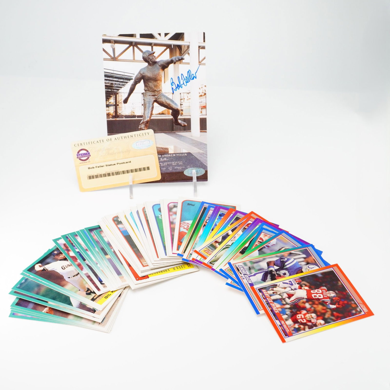 Bob Feller Autographed Steiner Sports Postcard and A Collection of Sports Trading Cards: This lot features an autographed postcard and a collection of sports trading cards. The postcard depicts the Bob Feller statue located at Progressive Field in Cleveland, Ohio, and is signed Bob Feller