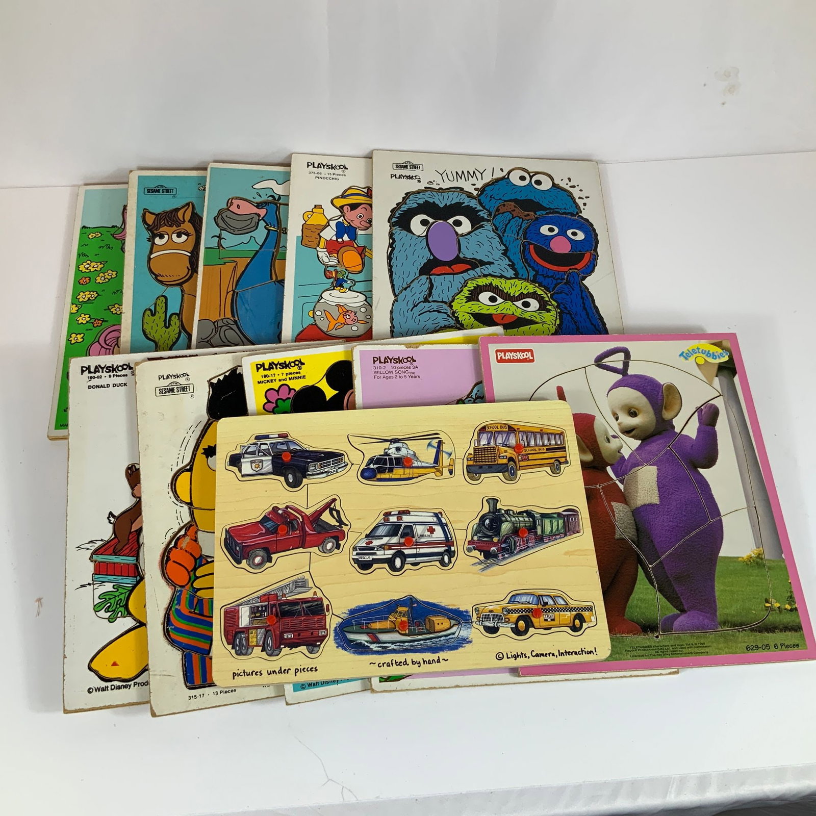 12 Playskool and Melissa and Doug Wooden Puzzle Toys: This collection of 12pc Playskool wooden puzzle toys features a variety of licensed characters and themes popular during the late 20th century. The group consists primarily of tray puzzles manufacture