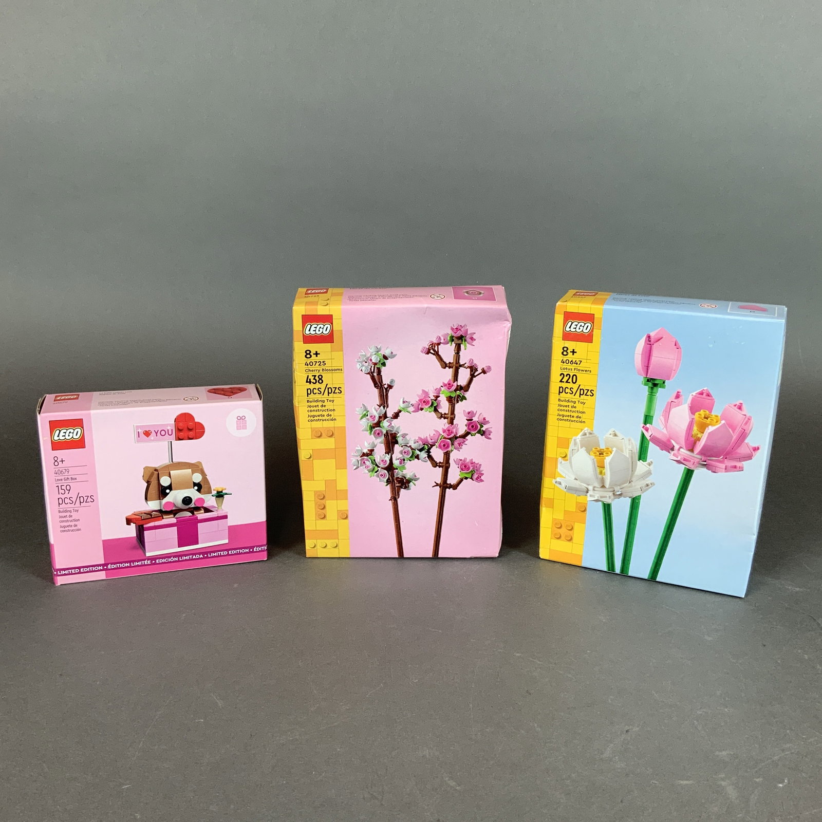 3pc LEGO Sets, Lotus Flowers, Cherry Blossoms, and Love Gift Box: This lot features three LEGO construction sets produced by the LEGO Group, each housed in its original retail packaging. The first item is the Lotus Flowers set (40647), which contains 220 plastic pie