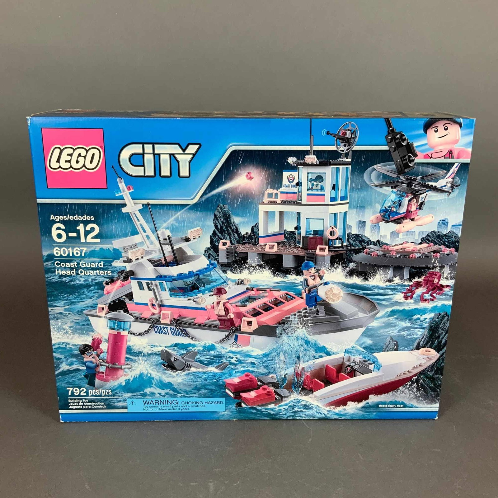 LEGO City Coast Guard Head Quarters Building Set 60167: This is a LEGO City Coast Guard Head Quarters construction set, model number 60167. The set is contained within its original retail box. According to the packaging, the set consists of 792 pieces and 