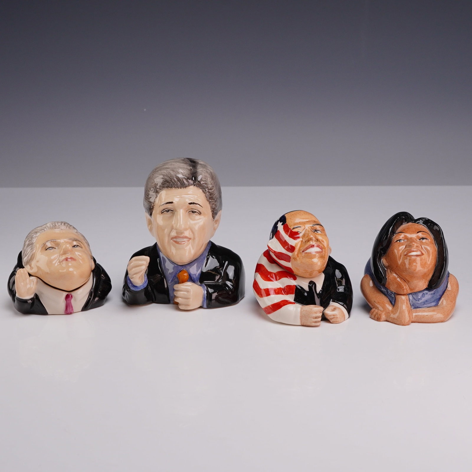 Lot of Four Kevin Francis Face Pots, American Political Figures: A set of four hand-painted glazed ceramic lidded jars, known as Face Pots, manufactured by Kevin Francis Ceramics. Each pot is modeled as a caricature of a prominent American political figure with a r