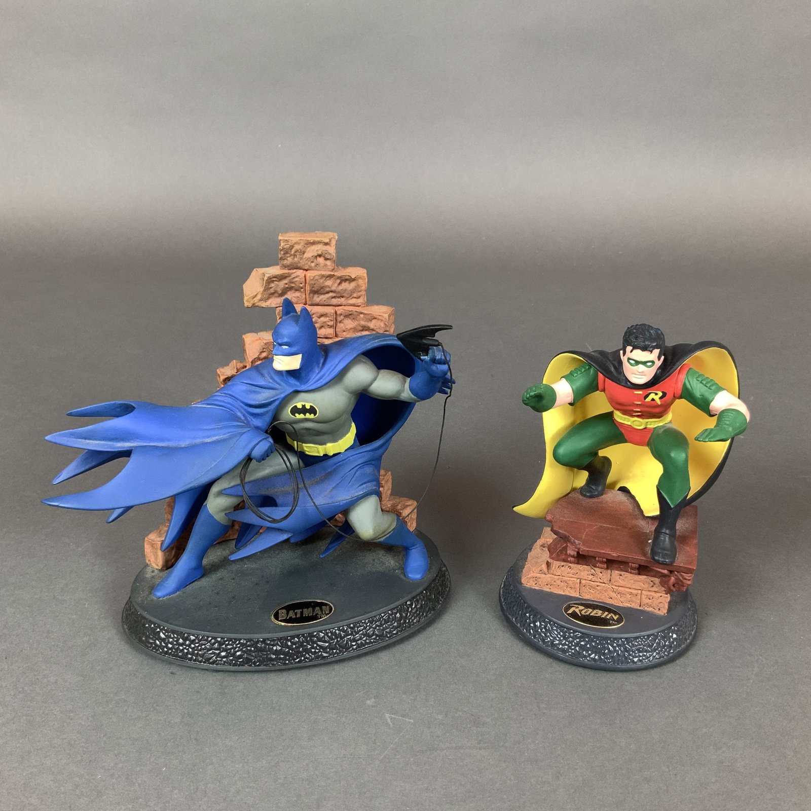2pc Hallmark DC Comics Modern Era Batman Figurines, Guardian of Gotham City and World's Bravest: This pair of handcrafted 1996 Hallmark DC Super Heroes Modern Era figurines, sculpted by Chad, features Batman and Robin in dynamic poses leaping over red brick walls. The Batman figure wears his clas