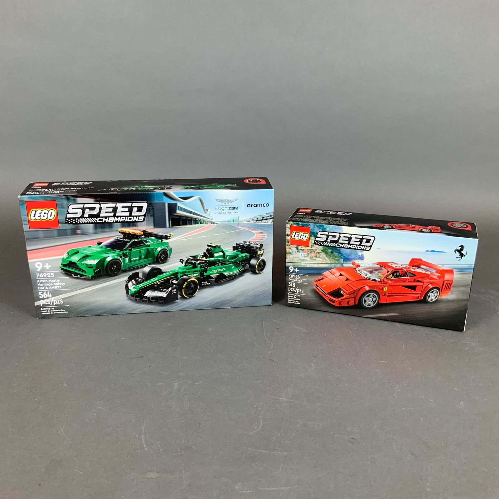Two LEGO Speed Champions Construction Sets, Ferrari F40 and Aston Martin Vantage Safety Car & AMR23: This lot consists of two factory-sealed construction sets from the LEGO Group Speed Champions series. The first set is the Ferrari F40 (Set 76934), which includes 318 pieces to build the iconic superc