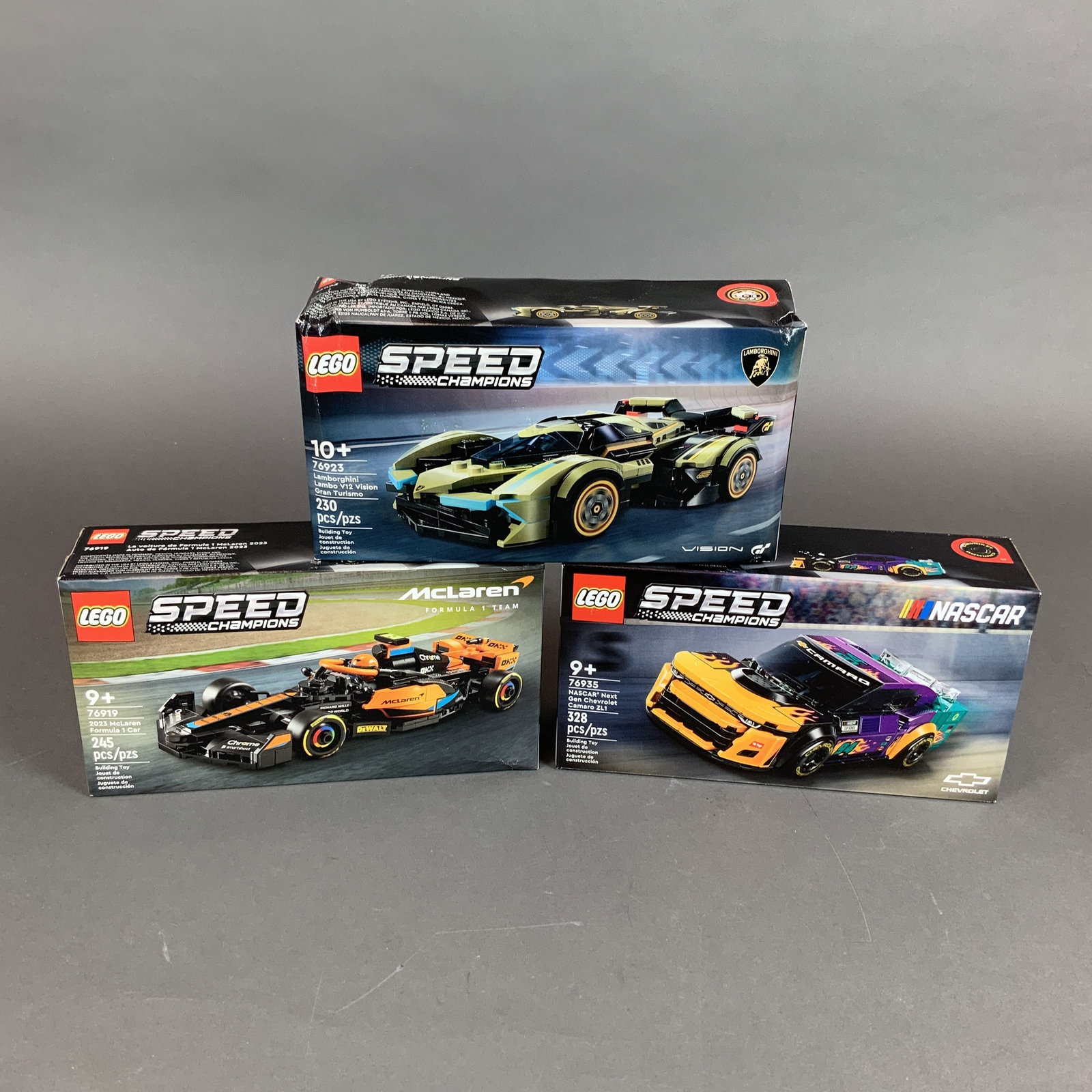 3pc LEGO Speed Champions Sets: Lamborghini 76923, NASCAR Chevrolet 76935, and McLaren 76919: This lot contains three LEGO Speed Champions series construction sets, each featuring detailed plastic models of high-performance racing vehicles. The collection includes the following: One Lamborghin